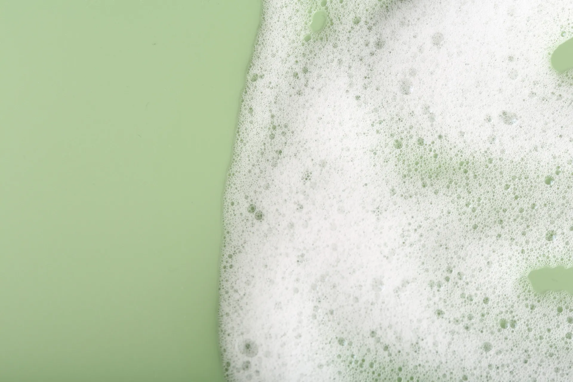 Mãos ensaboadas com muita espuma, representando a ação dos sulfatos em produtos de limpeza.