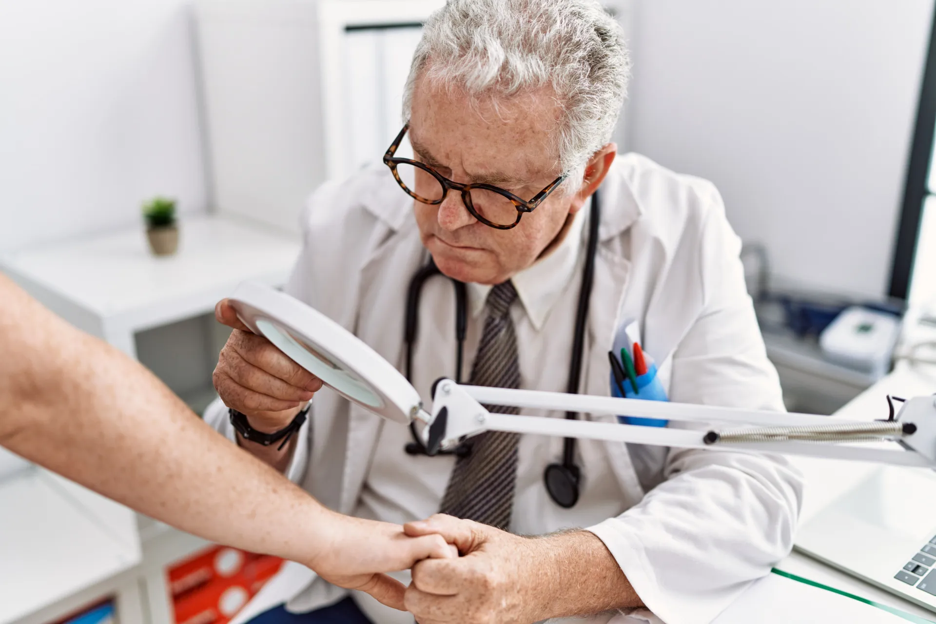 Um dermatologista examinando a pele de um paciente com uma lupa especial.