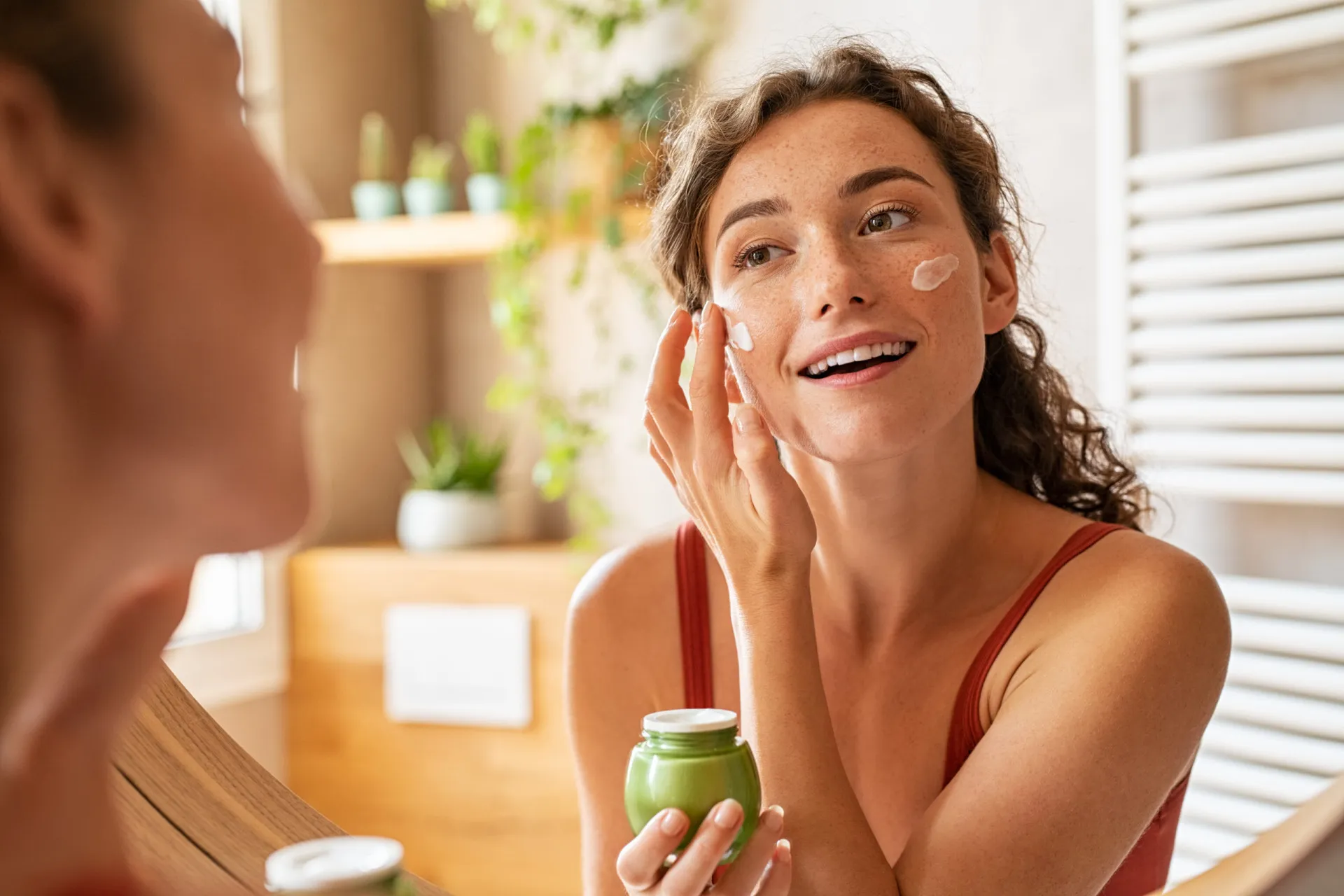 Uma pessoa lendo atentamente o rótulo de um produto cosmético, em dúvida sobre a compra.