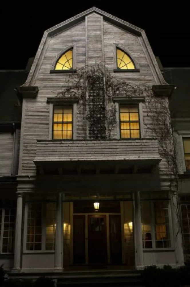 Ryan Reynolds no remake de 'Horror em Amityville', parecendo atormentado dentro da icônica casa.