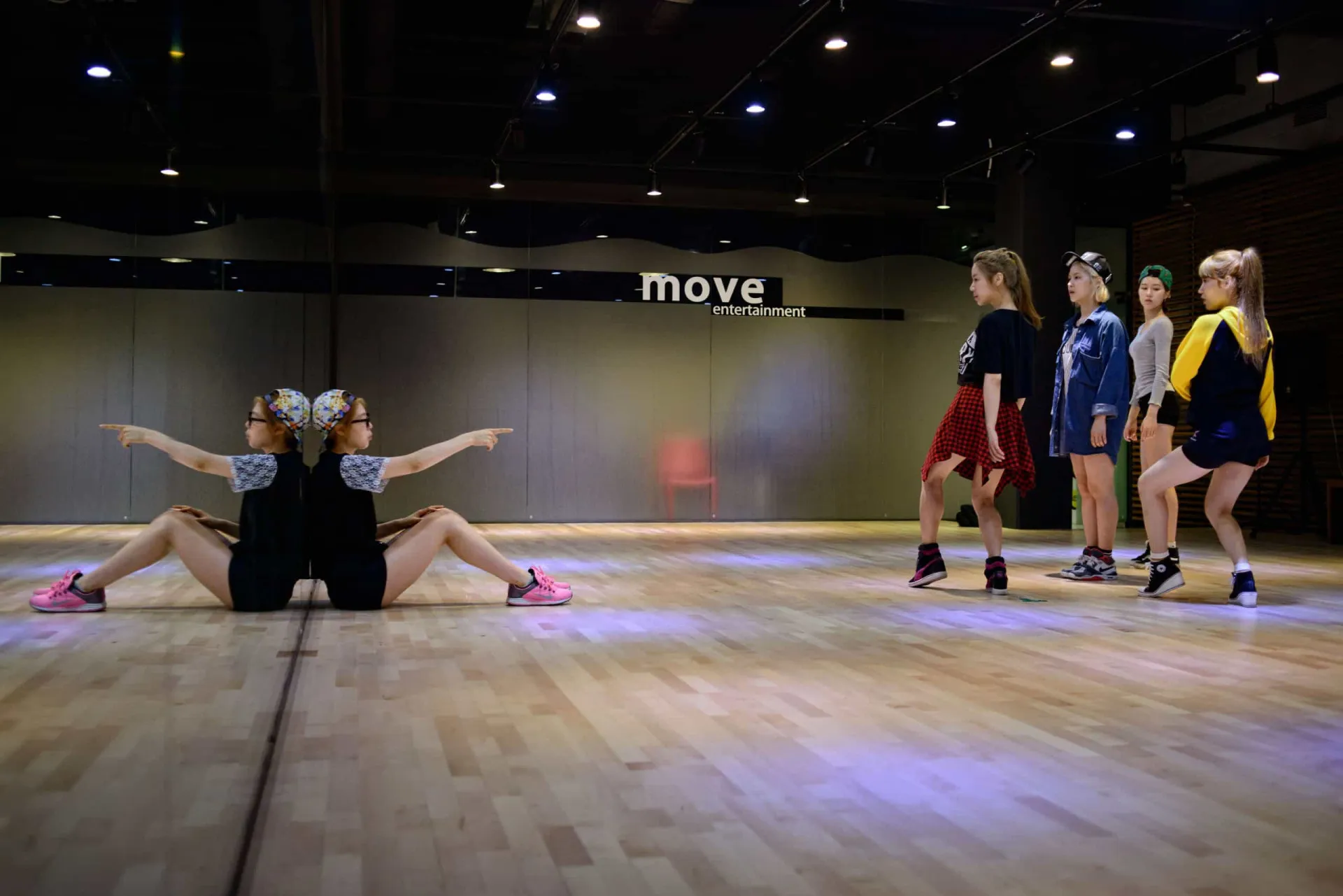 Grupo de K-pop treinando coreografia de forma sincronizada e intensa.