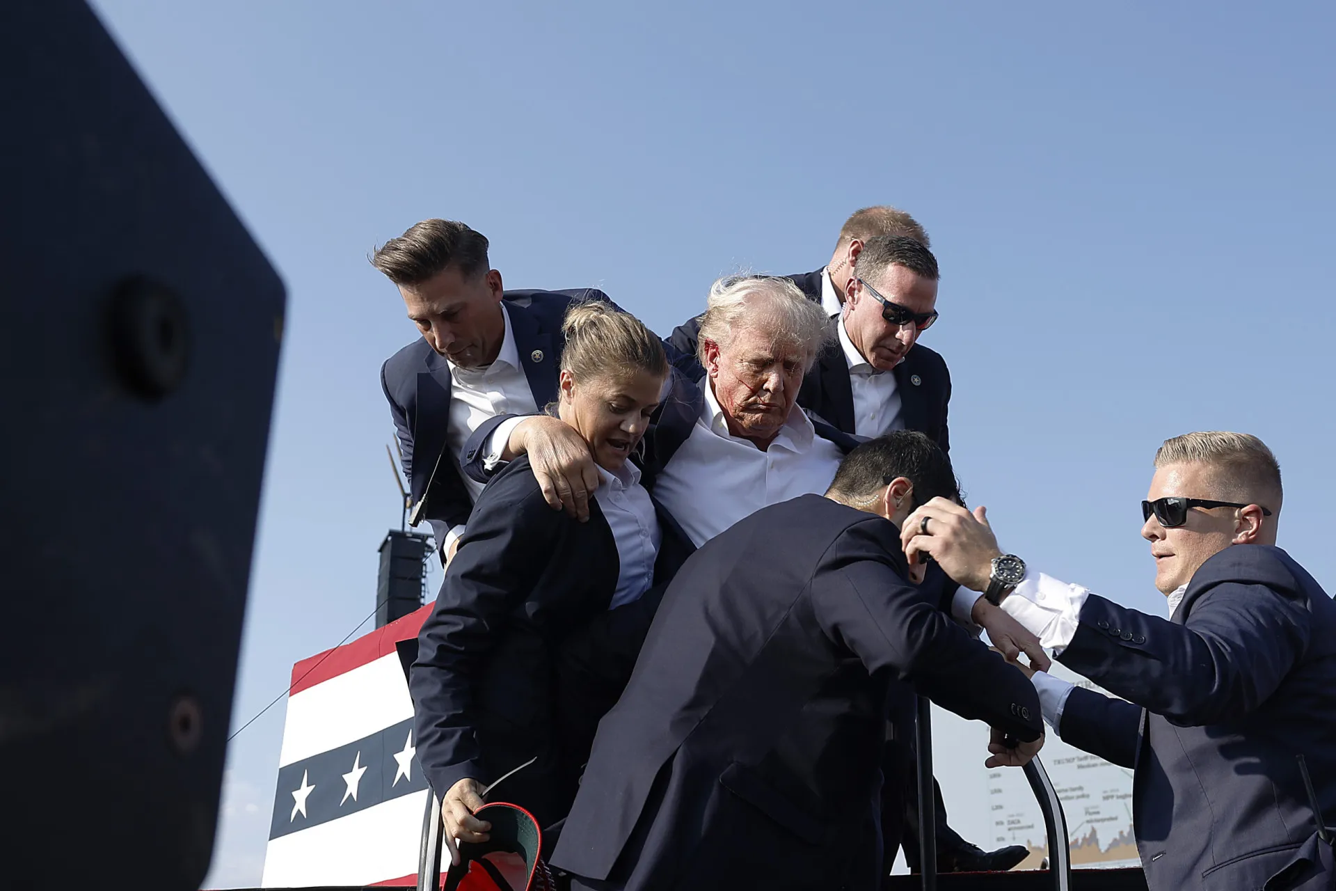 Agentes do serviço secreto acompanhando Donald Trump, demonstrando o alto nível de segurança.