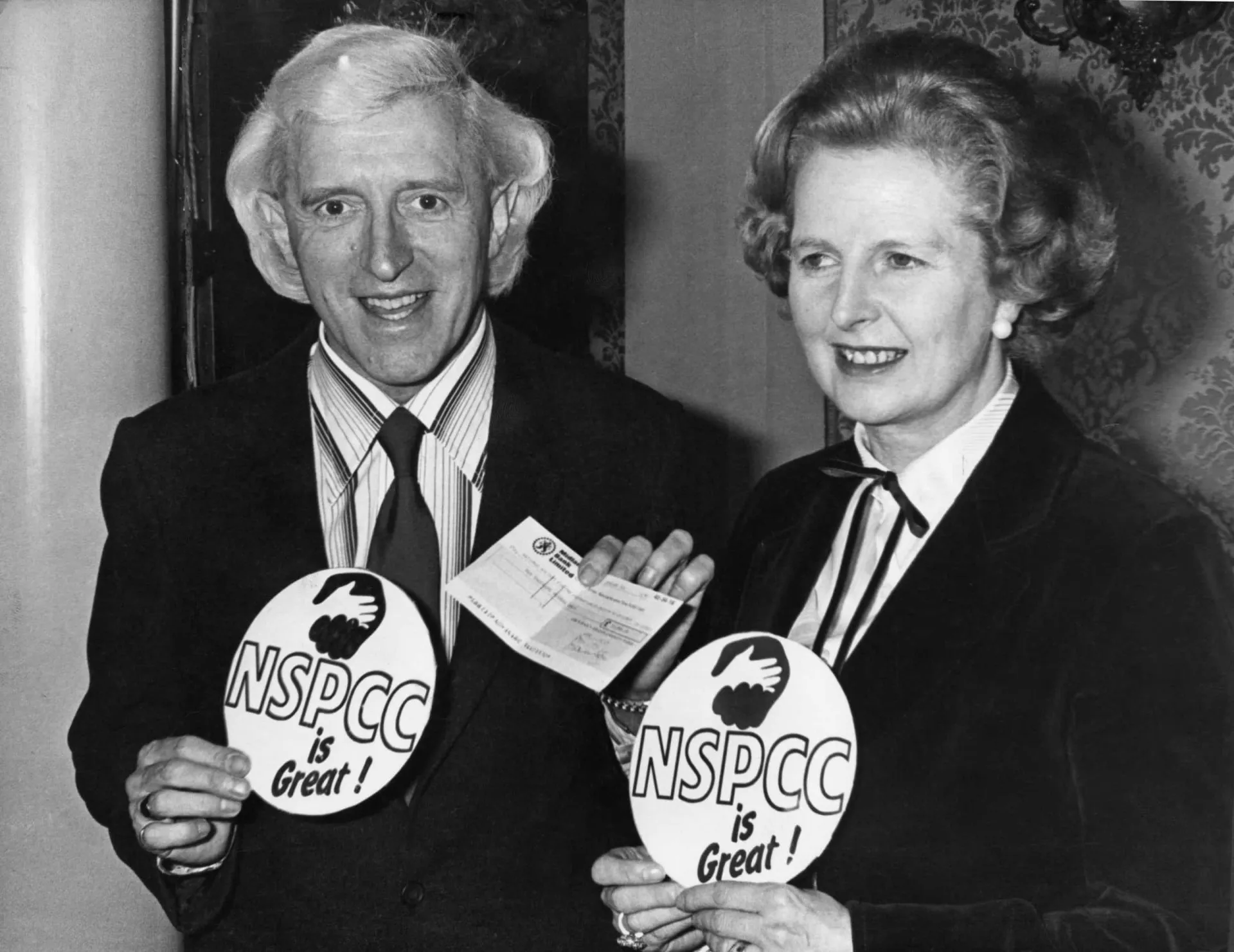 O apresentador britânico Jimmy Savile com seu cabelo loiro platinado e um sorriso largo.