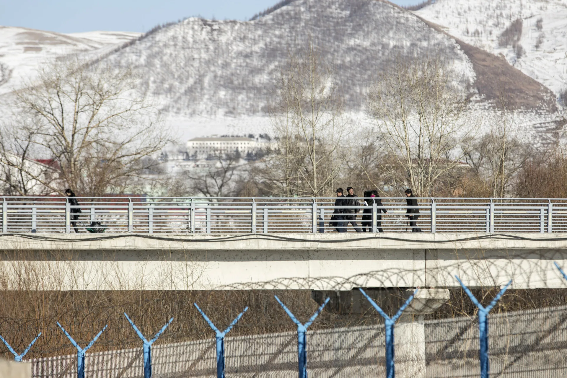 Pessoas atravessando a ponte de Hyesan, na Coreia do Norte, em direção a Changbai, na China.
