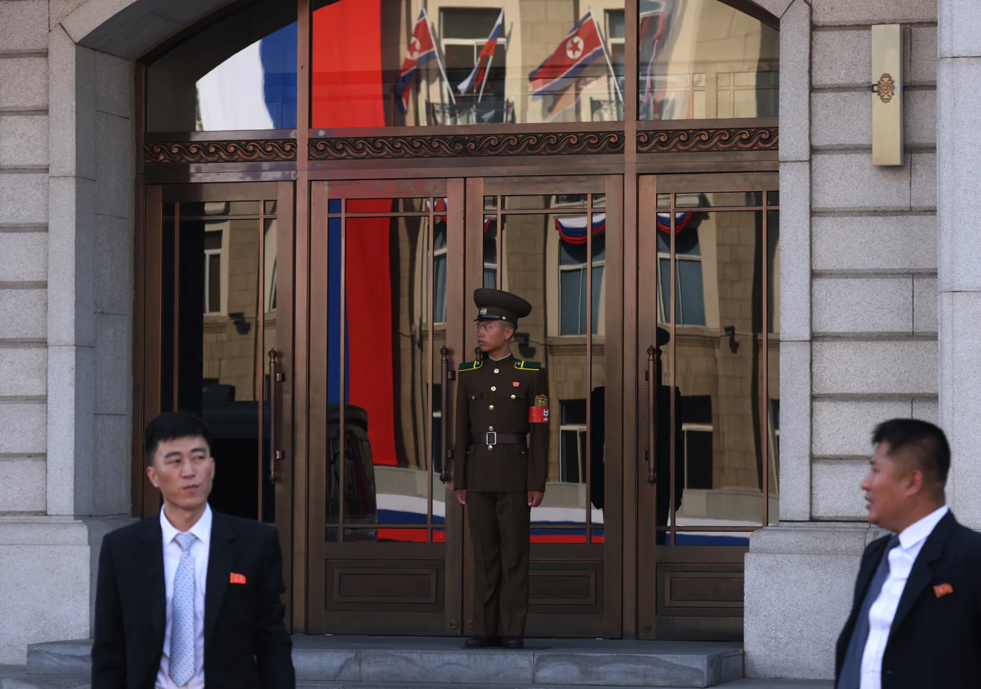 Oficial do exército norte-coreano em guarda na entrada de um prédio do governo.