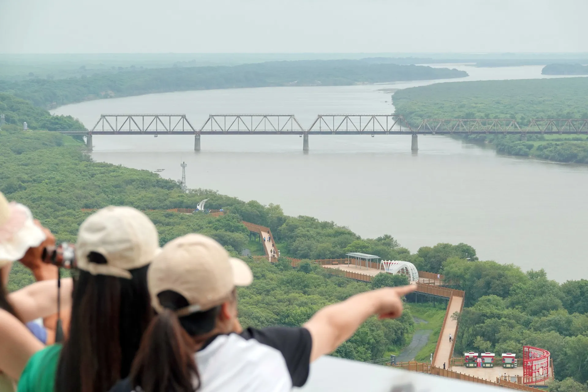 Turistas na China observando a Ponte da Amizade Coreia-Rússia sobre o rio Tuman.