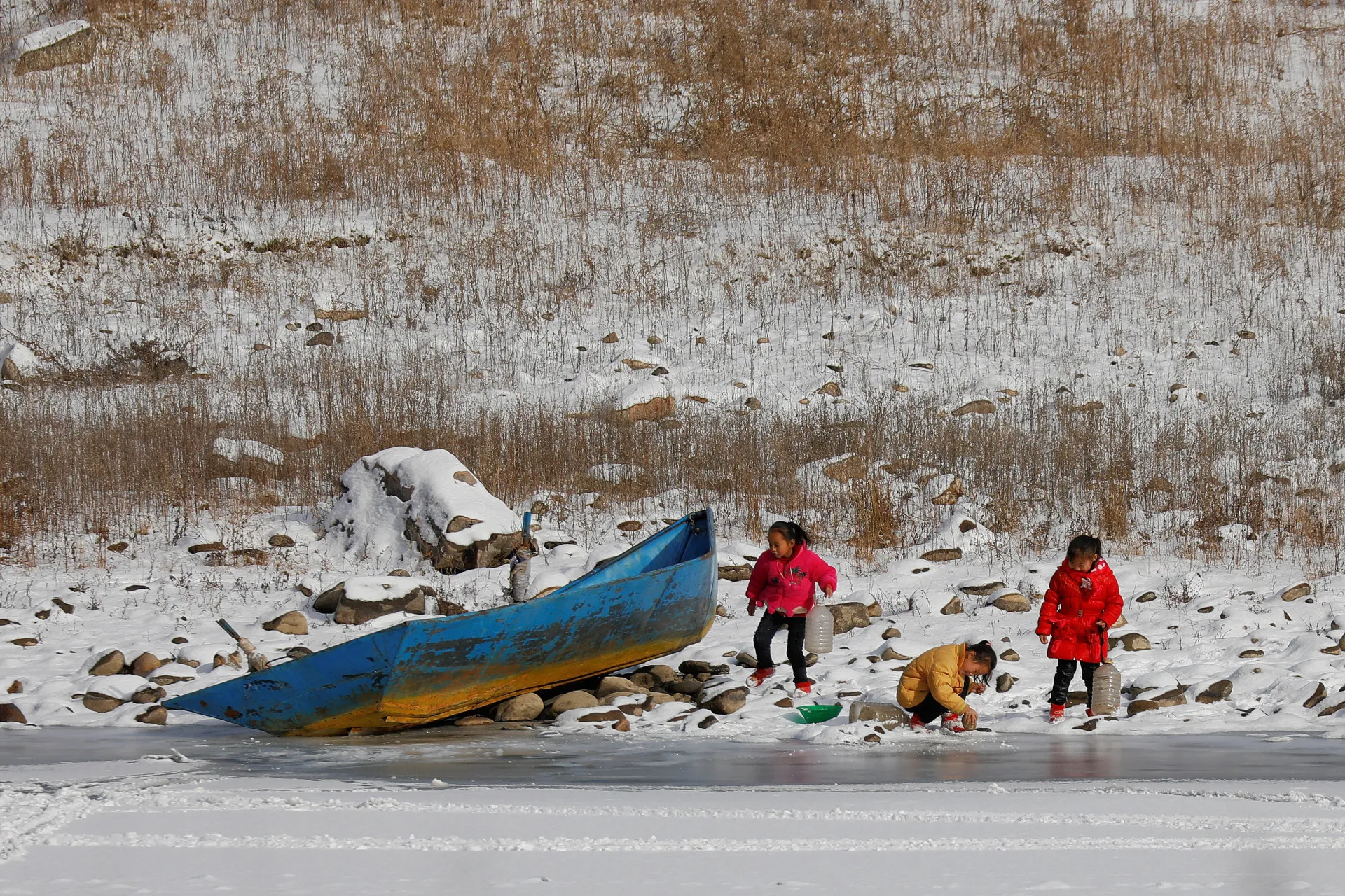 Crianças norte-coreanas brincando e coletando água nas margens do rio Yalu.