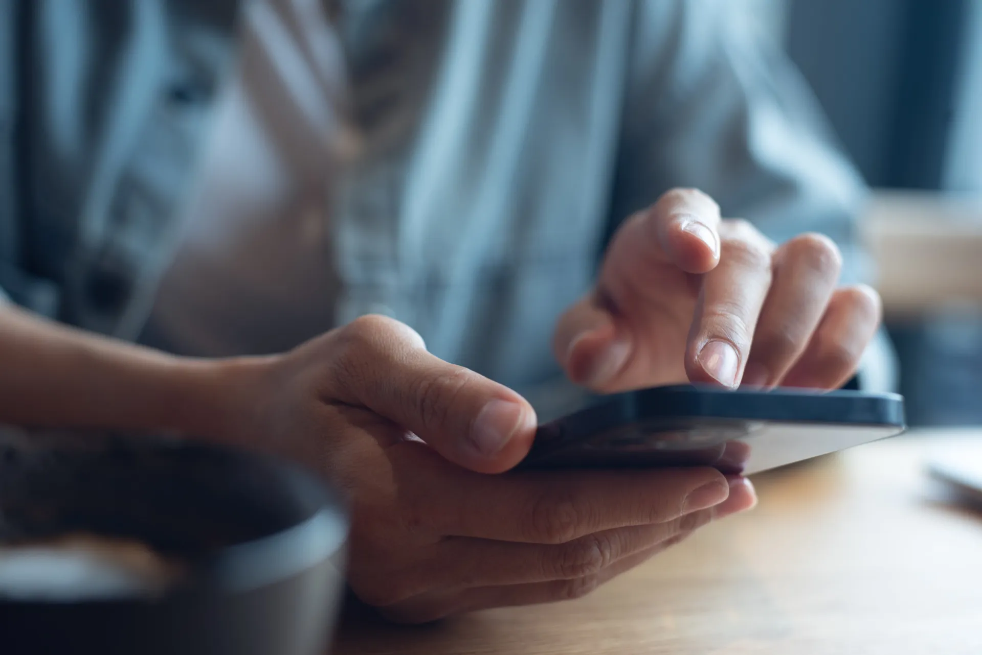 Mãos digitando rapidamente em um teclado de celular, com letras voando pela tela.