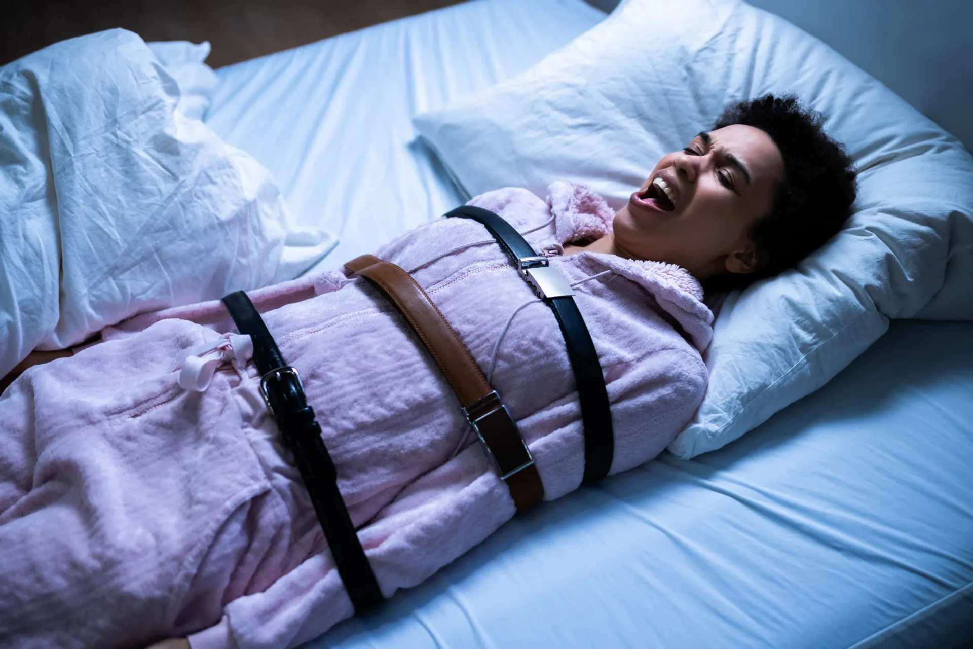 Pessoa deitada na cama, consciente mas incapaz de se mover, enquanto uma figura sombria a observa.