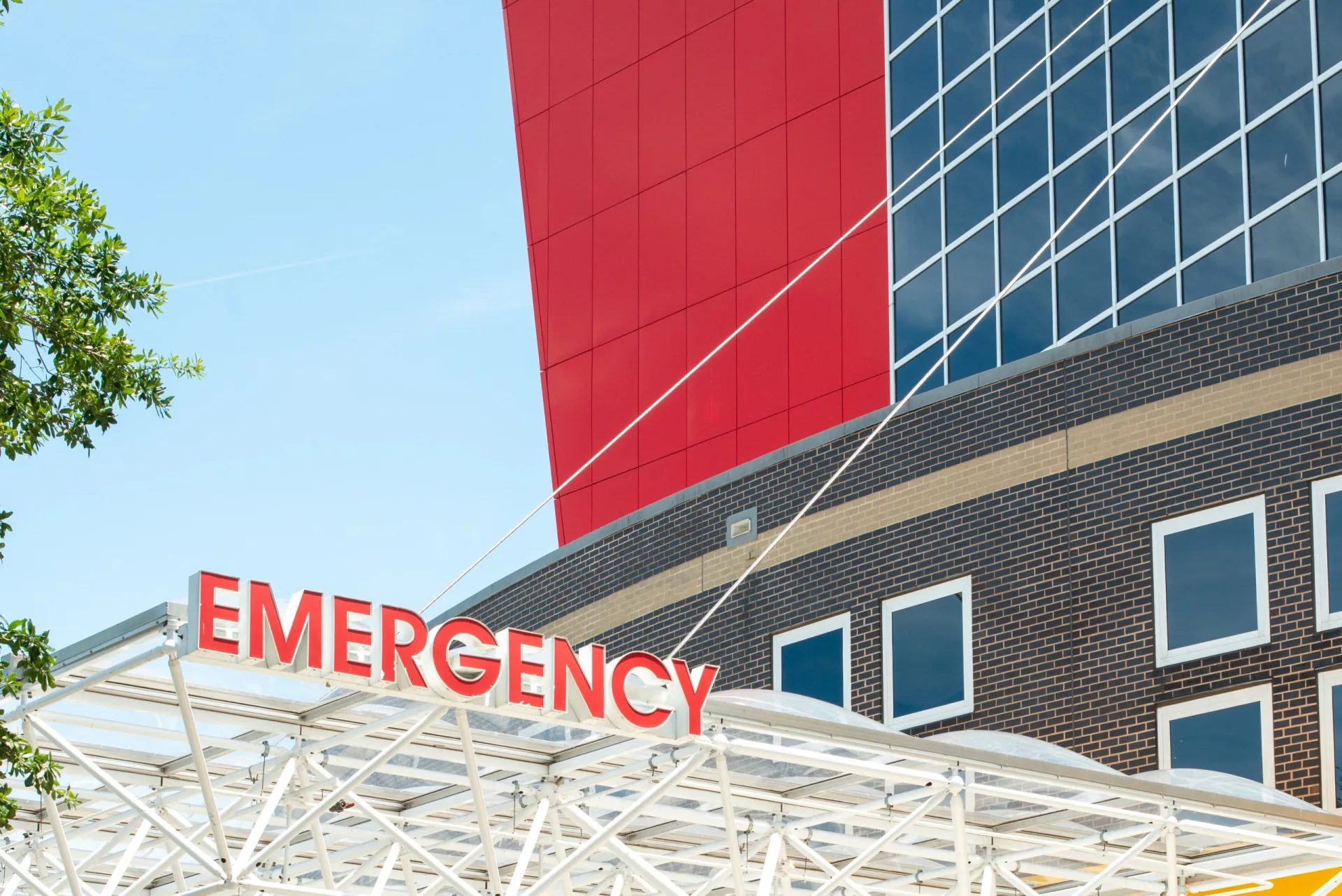 Fachada de um hospital com a placa de emergência bem visível.