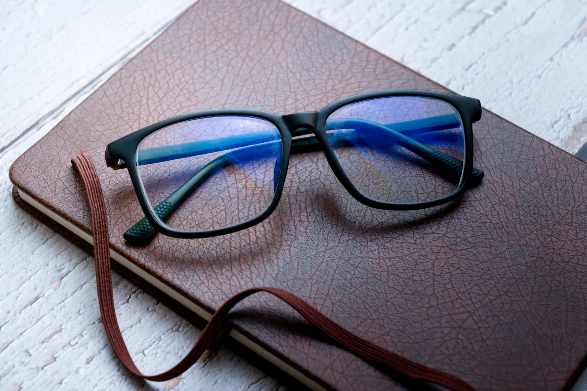 Pessoa usando óculos com filtro de luz azul enquanto trabalha no computador.