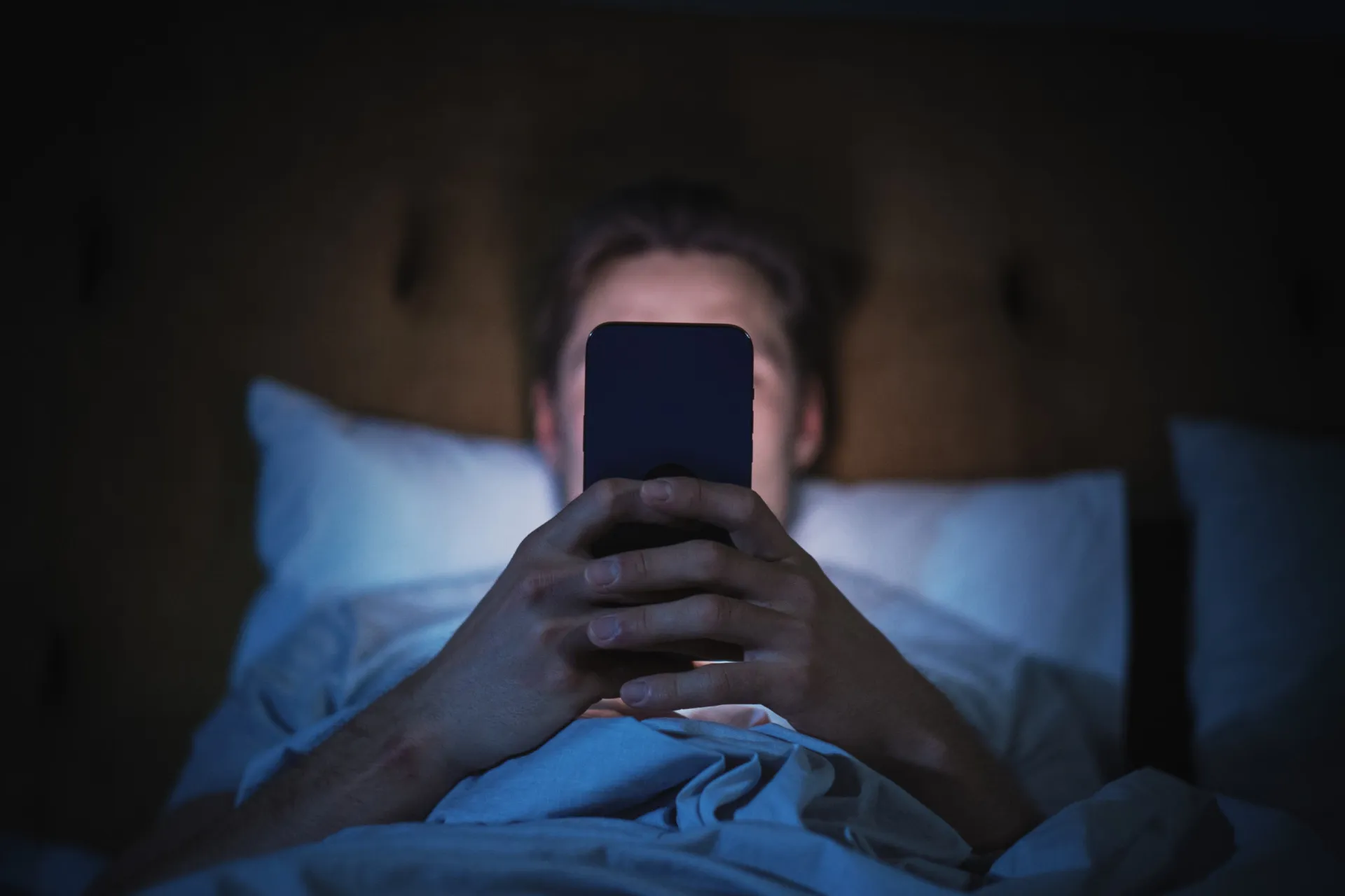 Dedo de uma pessoa rolando o feed de uma rede social em um smartphone.