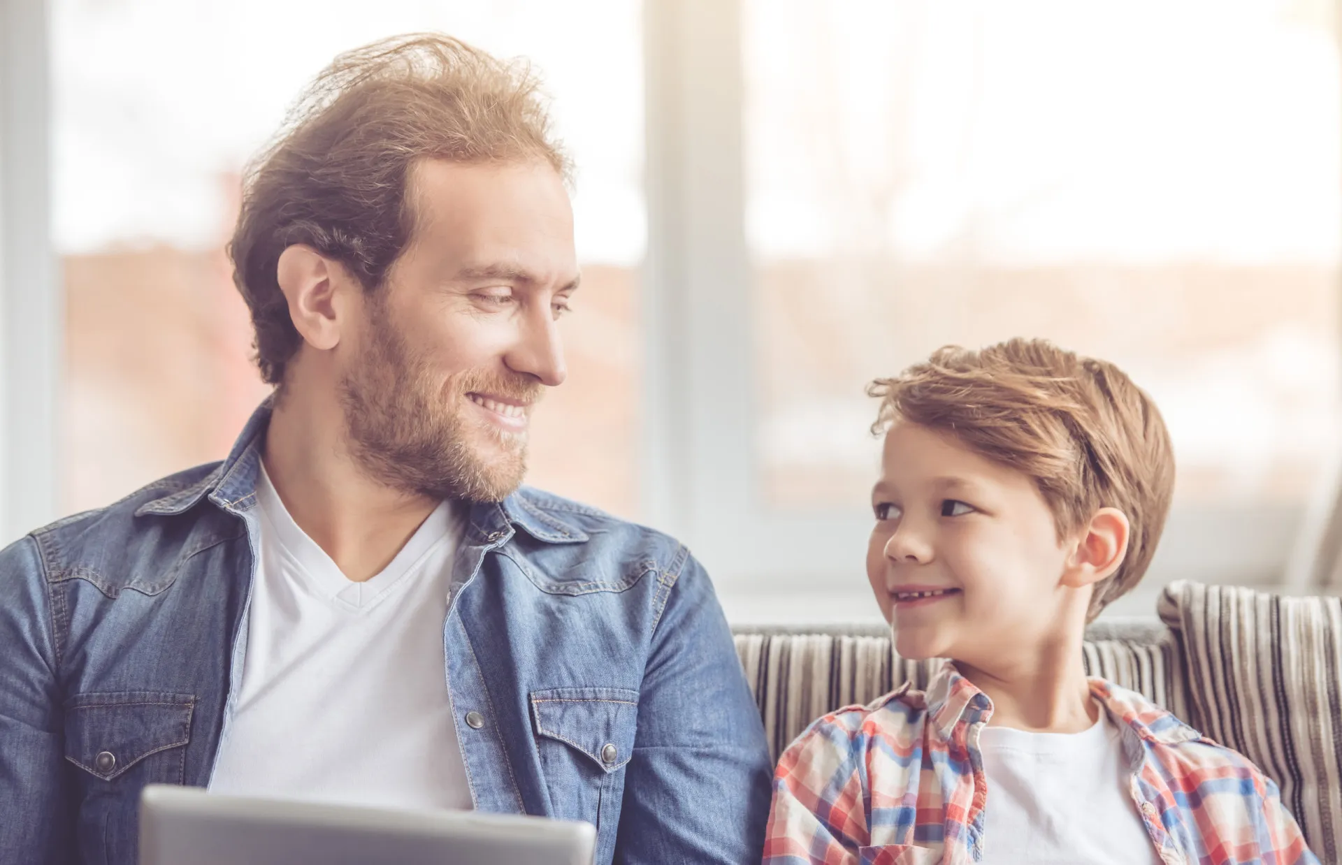 Pai e filho conversando e mantendo contato visual, o que demonstra confiança e conexão.