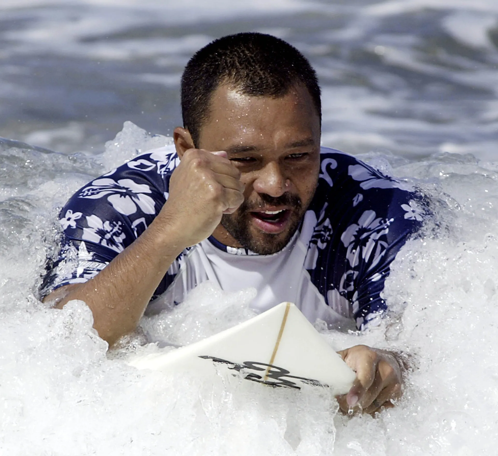 Sunny Garcia com sua postura poderosa, representando o surfe havaiano.