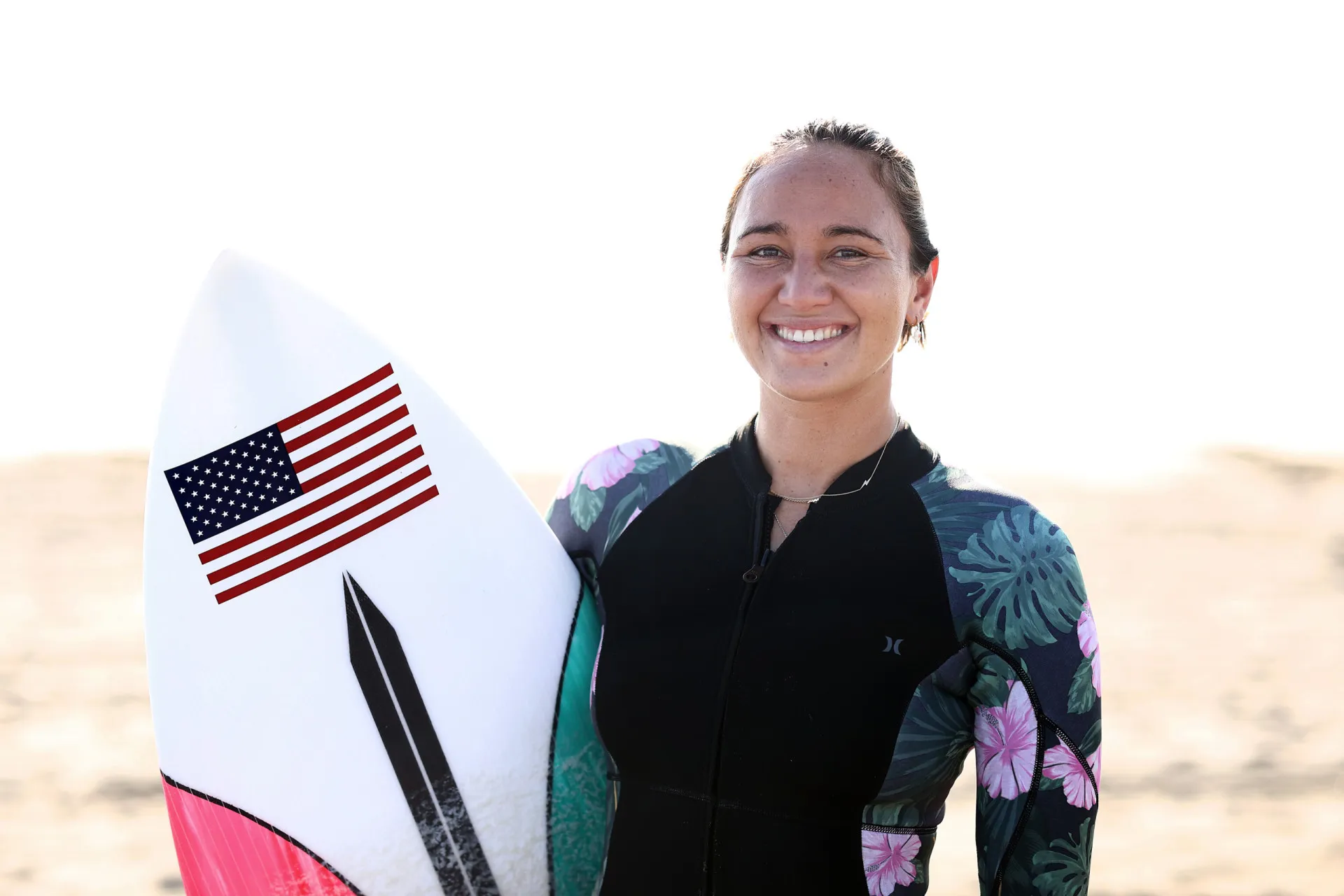 Carissa Moore levantando um troféu de campeã mundial.