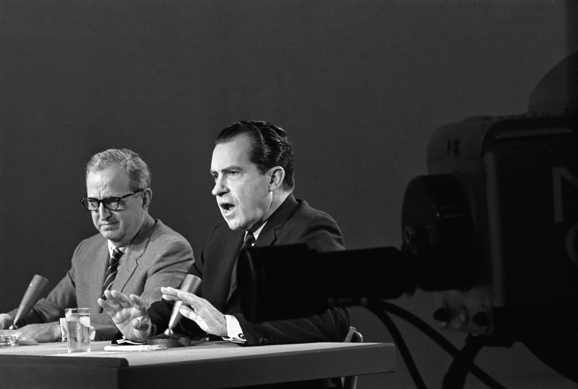 Richard Nixon em um discurso oficial, com uma expressão séria e determinada.
