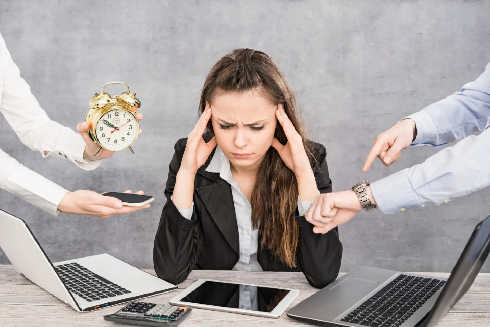 Funcionário estressado com vários papéis e tarefas acumuladas em sua mesa.