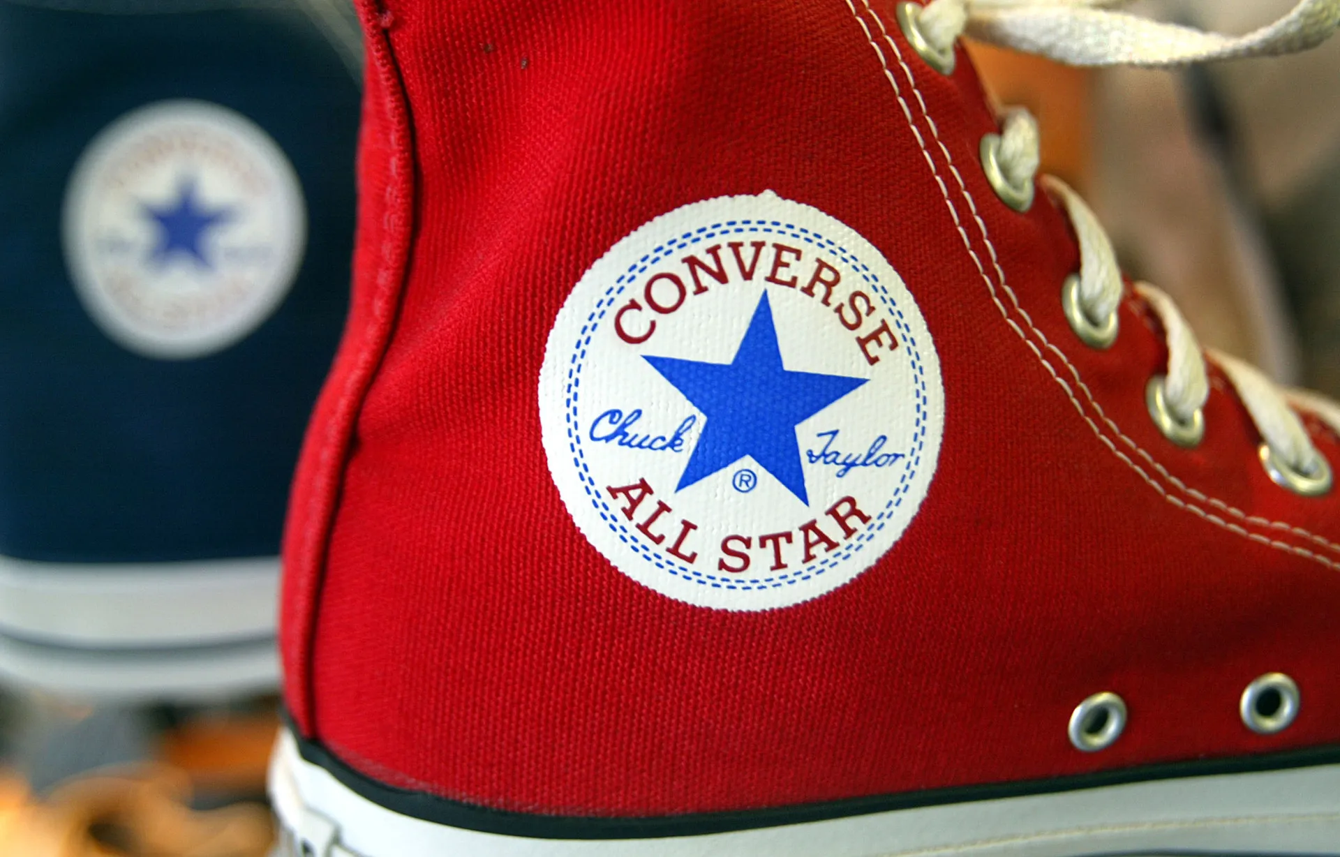 Um par de tênis All Star Converse azul claro aparece entre os sapatos de Maria Antonieta.