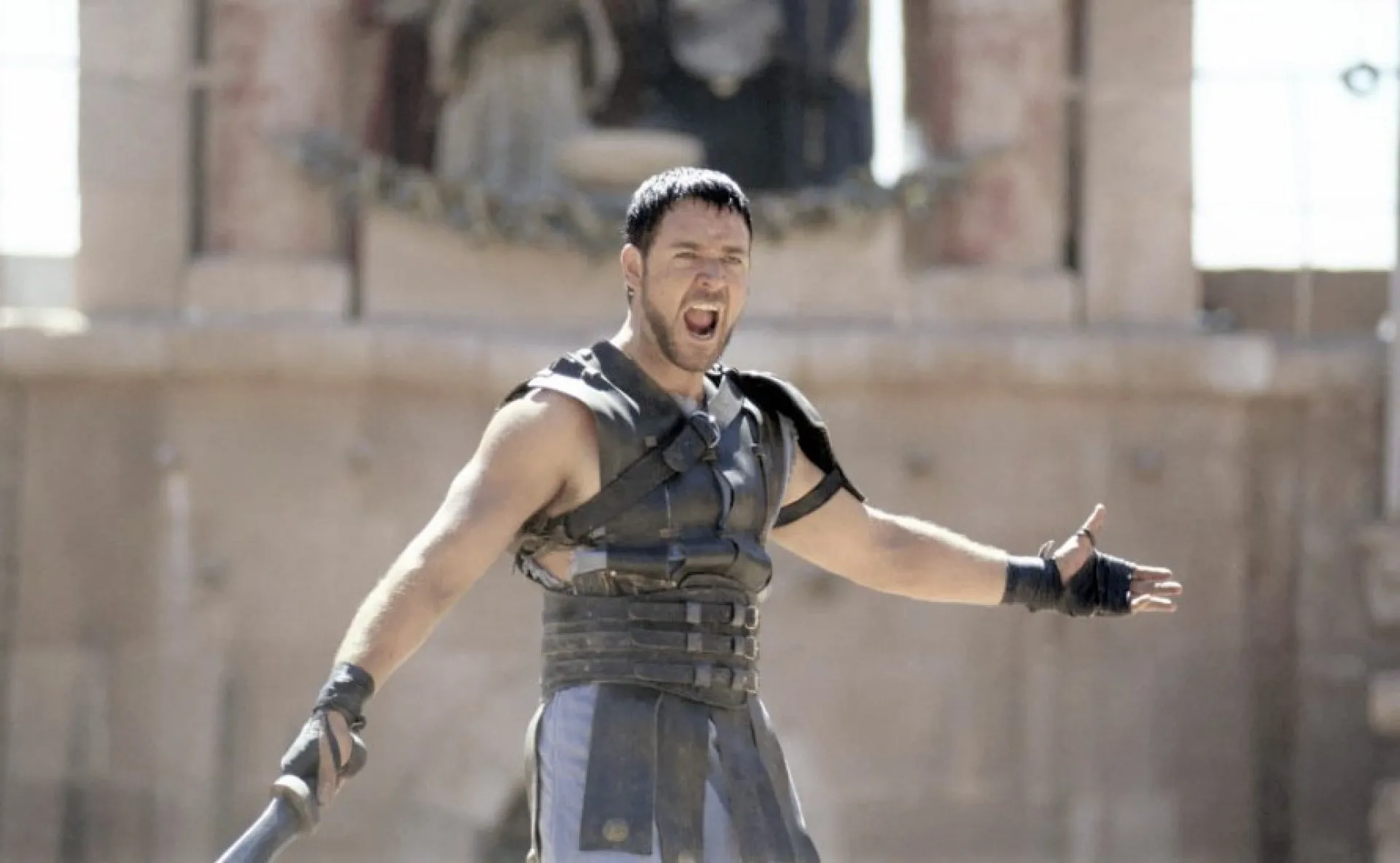 Russell Crowe como Maximus em uma cena de batalha no Coliseu no filme 'Gladiador'.