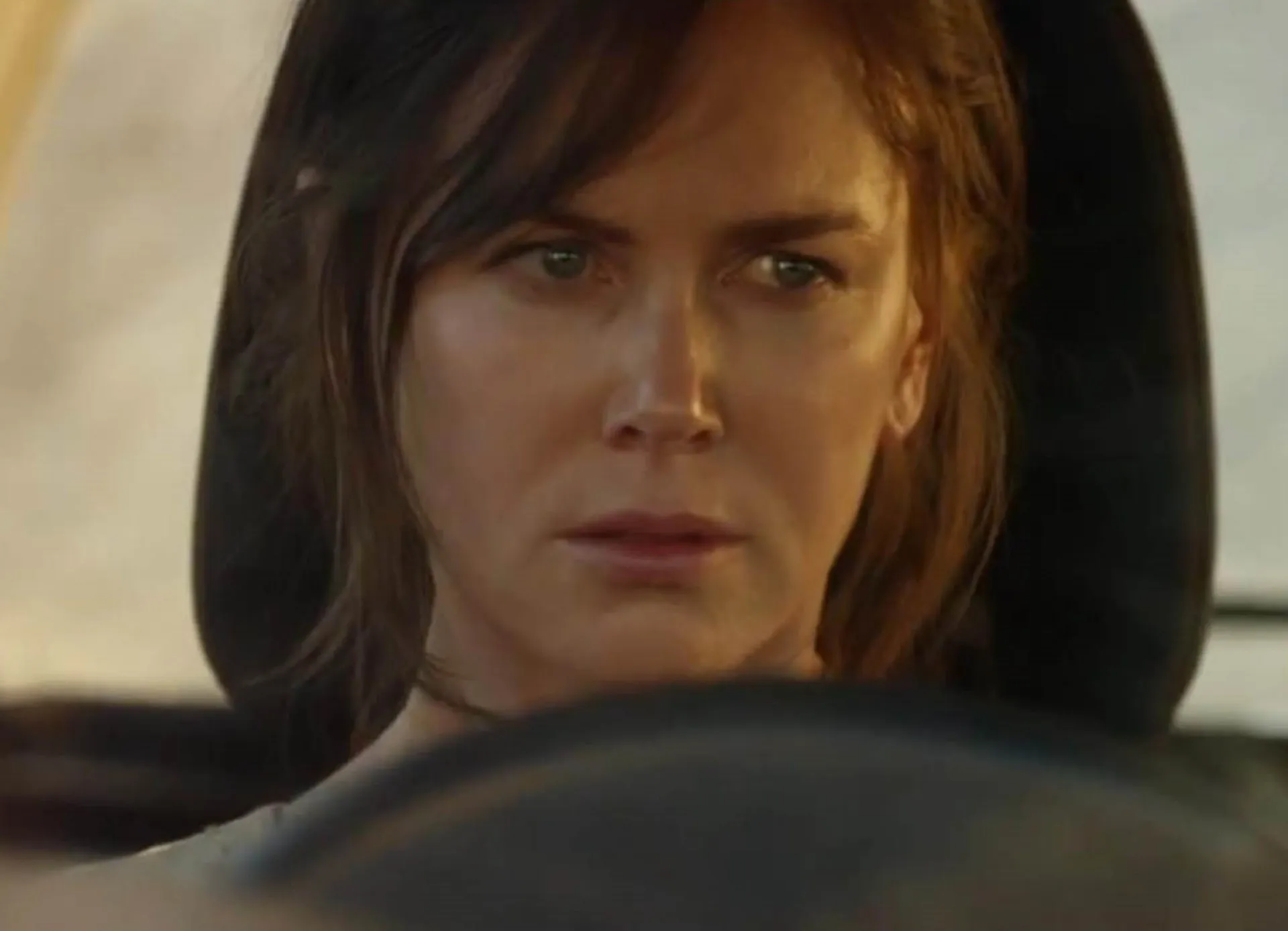 Nicole Kidman no drama 'Strangerland', com longos cabelos castanhos e uma aparência coberta de poeira.