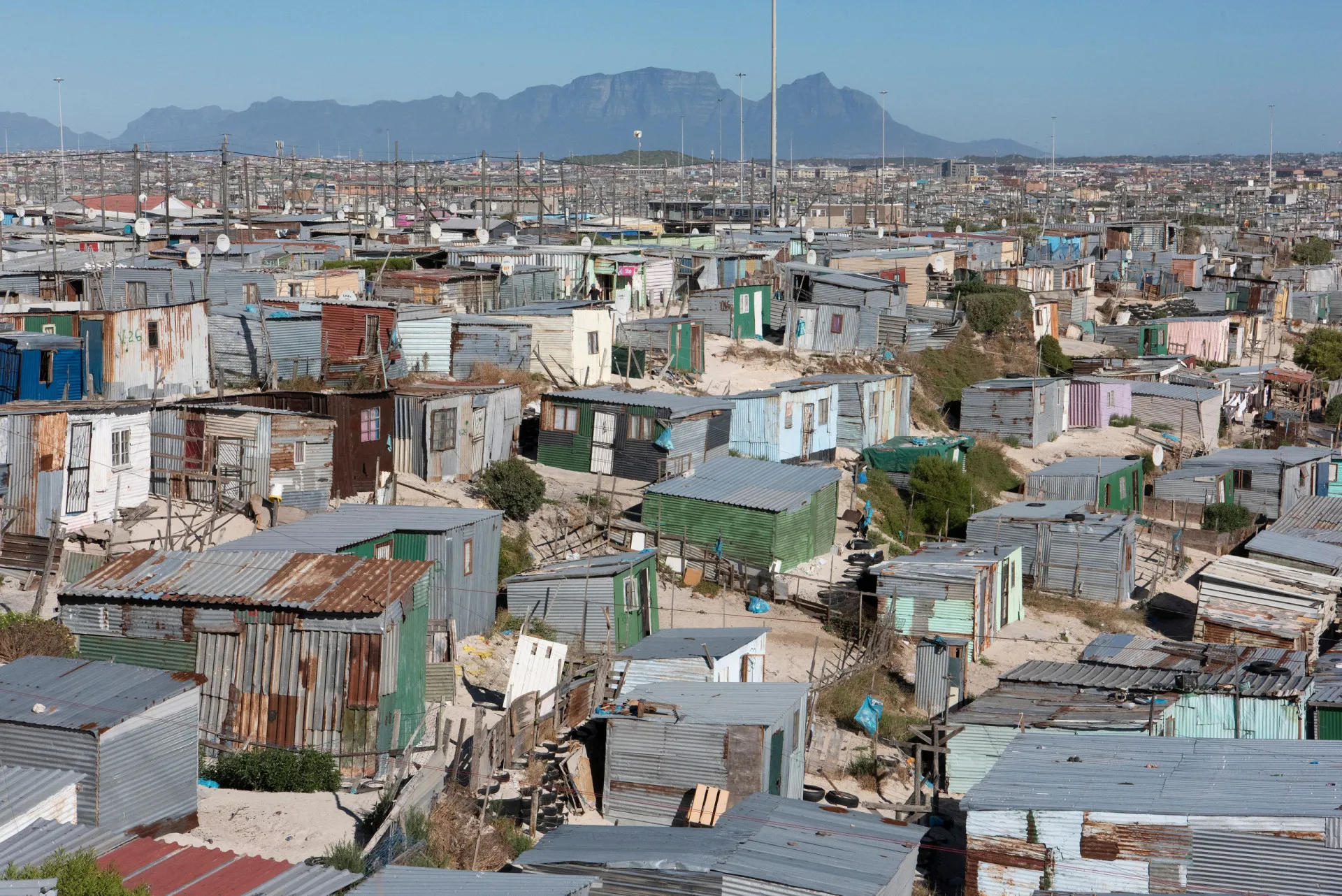 Vista panorâmica de Khayelitsha, na Cidade do Cabo, com milhares de pequenas casas se estendendo até o horizonte.
