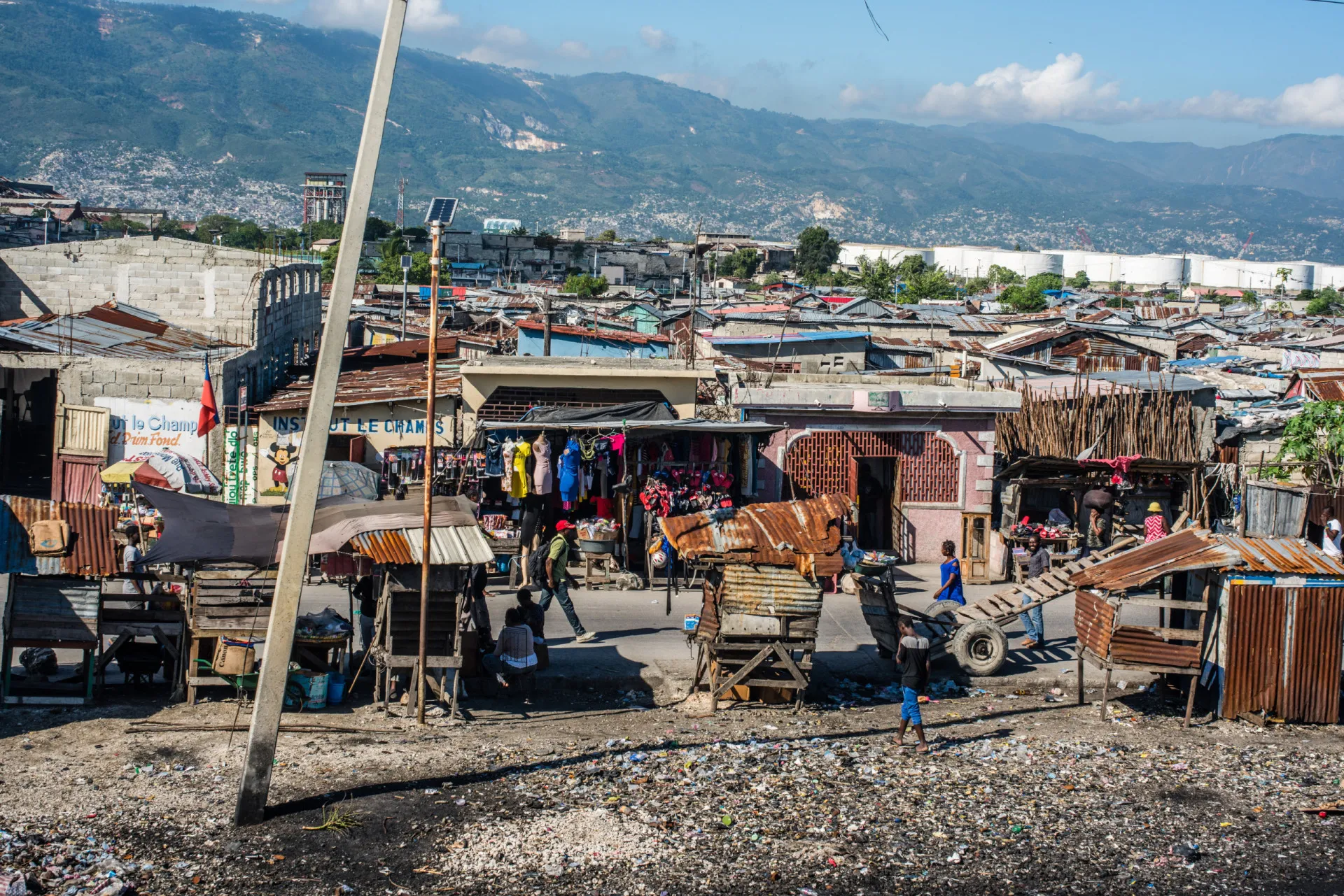 Crianças em uma rua inundada de Cité Soleil, no Haiti, refletindo as difíceis condições sanitárias.