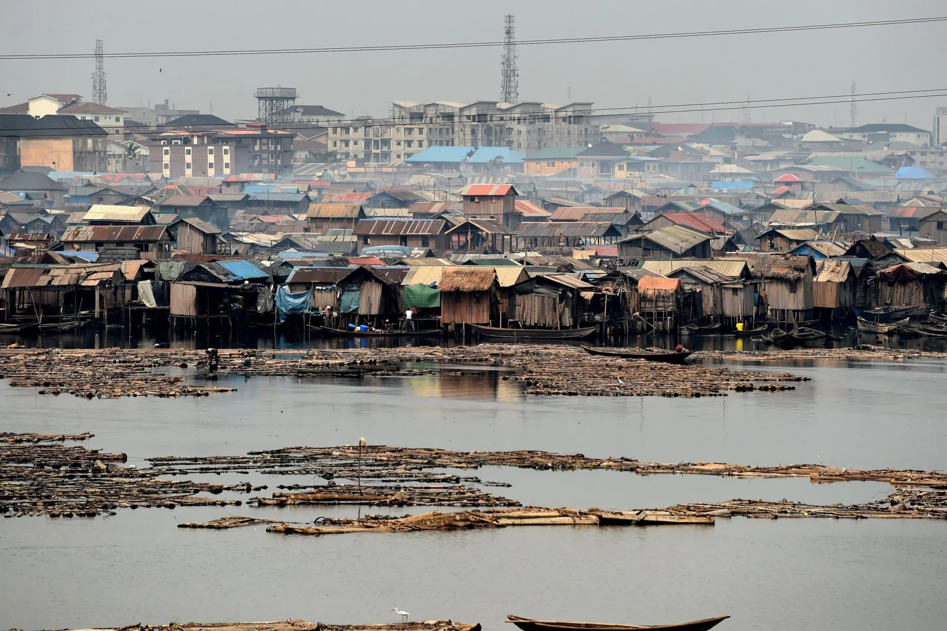 Casas construídas sobre palafitas na água na favela de Makoko, com canoas como principal meio de transporte.