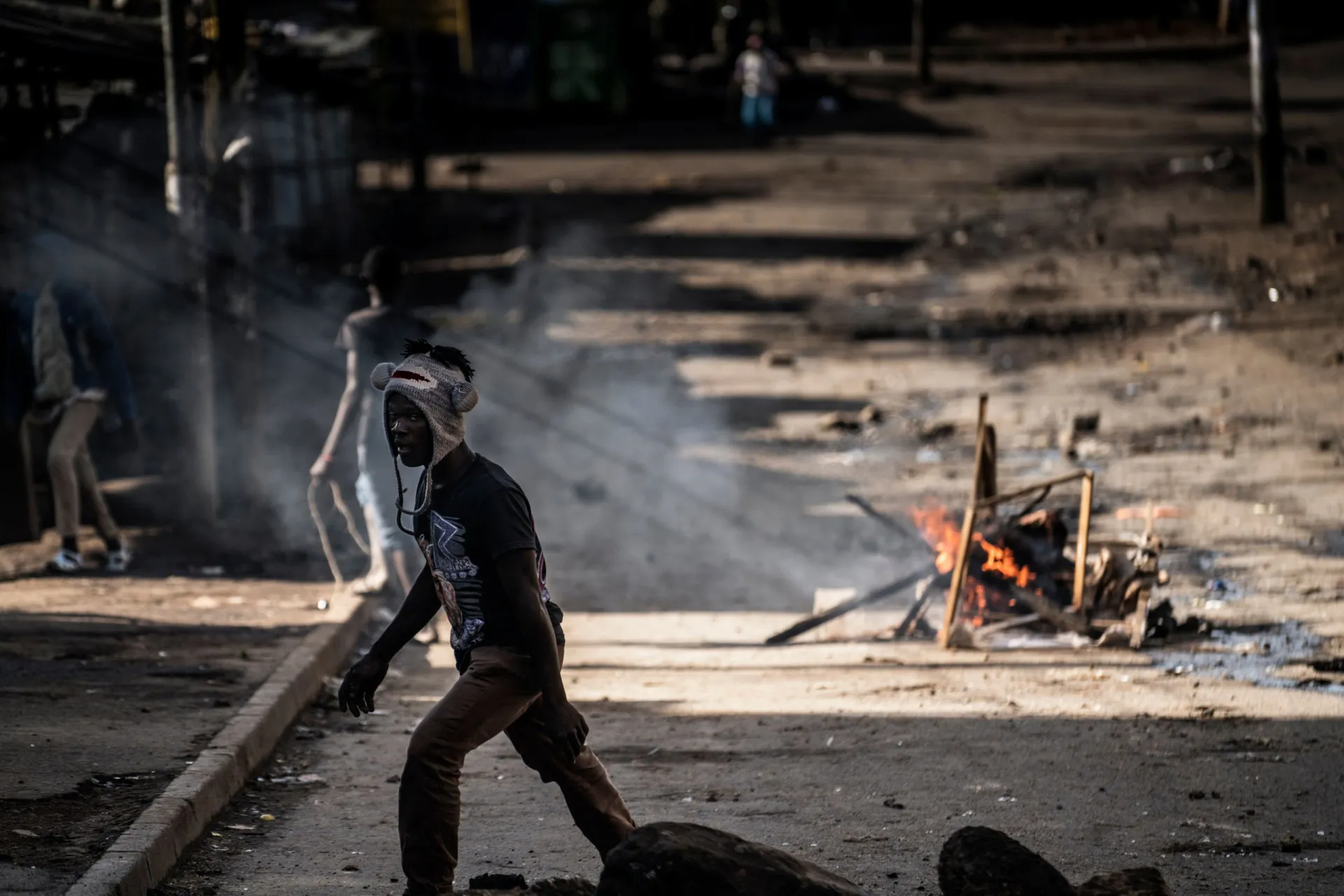 Um policial patrulhando uma rua em Mathare, simbolizando a tensa relação entre a comunidade e as forças de segurança.