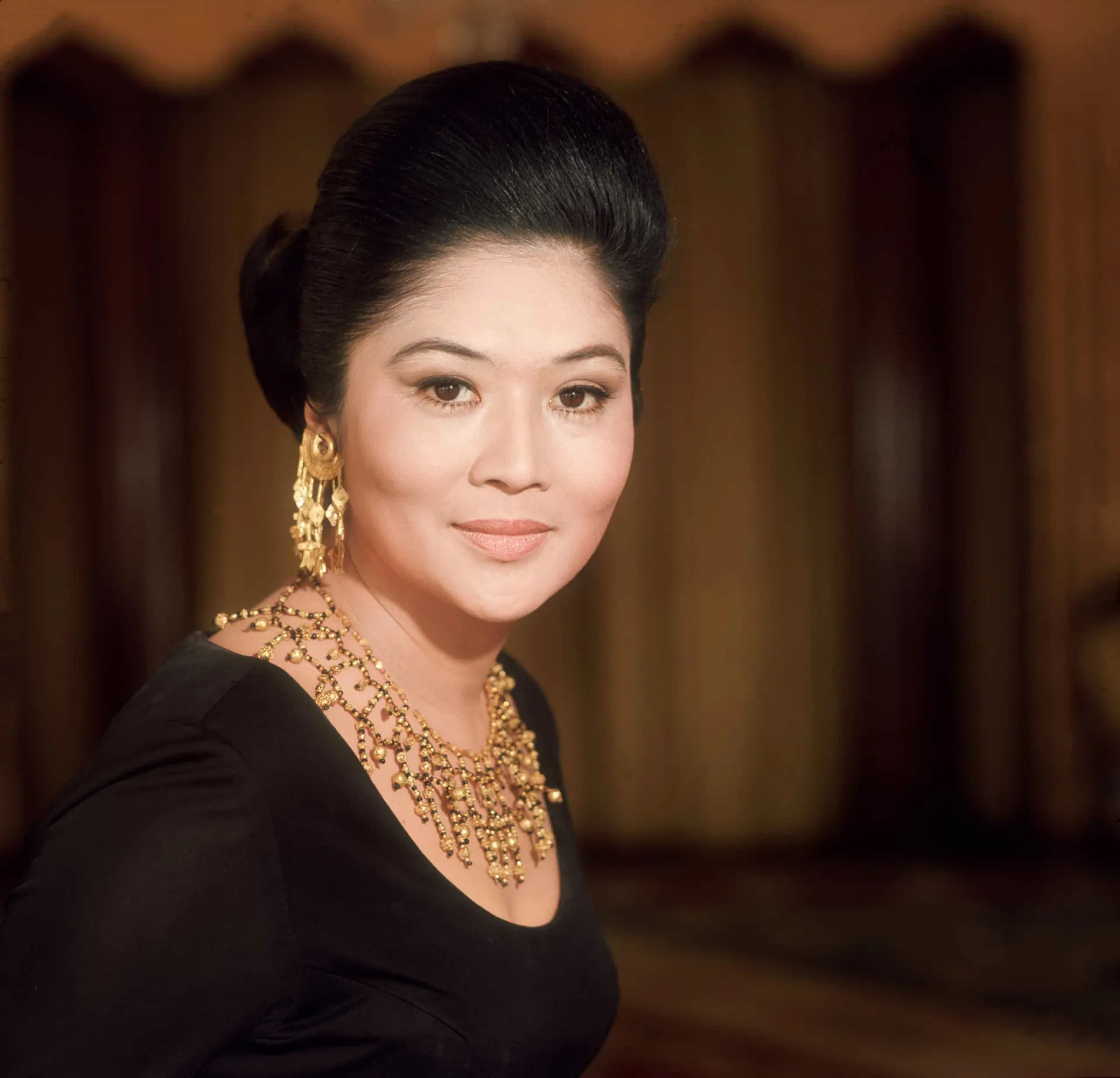 Imelda Marcos exibindo joias caras e roupas de grife.