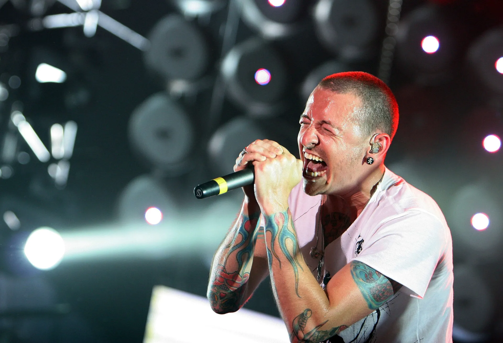 Chester Bennington, do Linkin Park, cantando com grande intensidade durante um show.