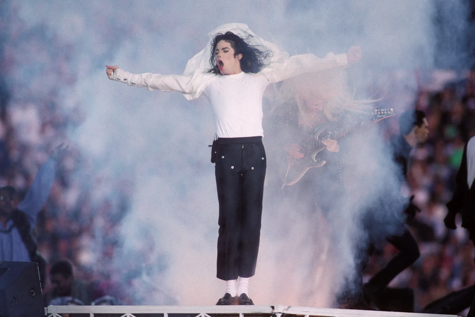 Michael Jackson em uma performance dramática de 'Earth Song', com vento e expressão intensa.