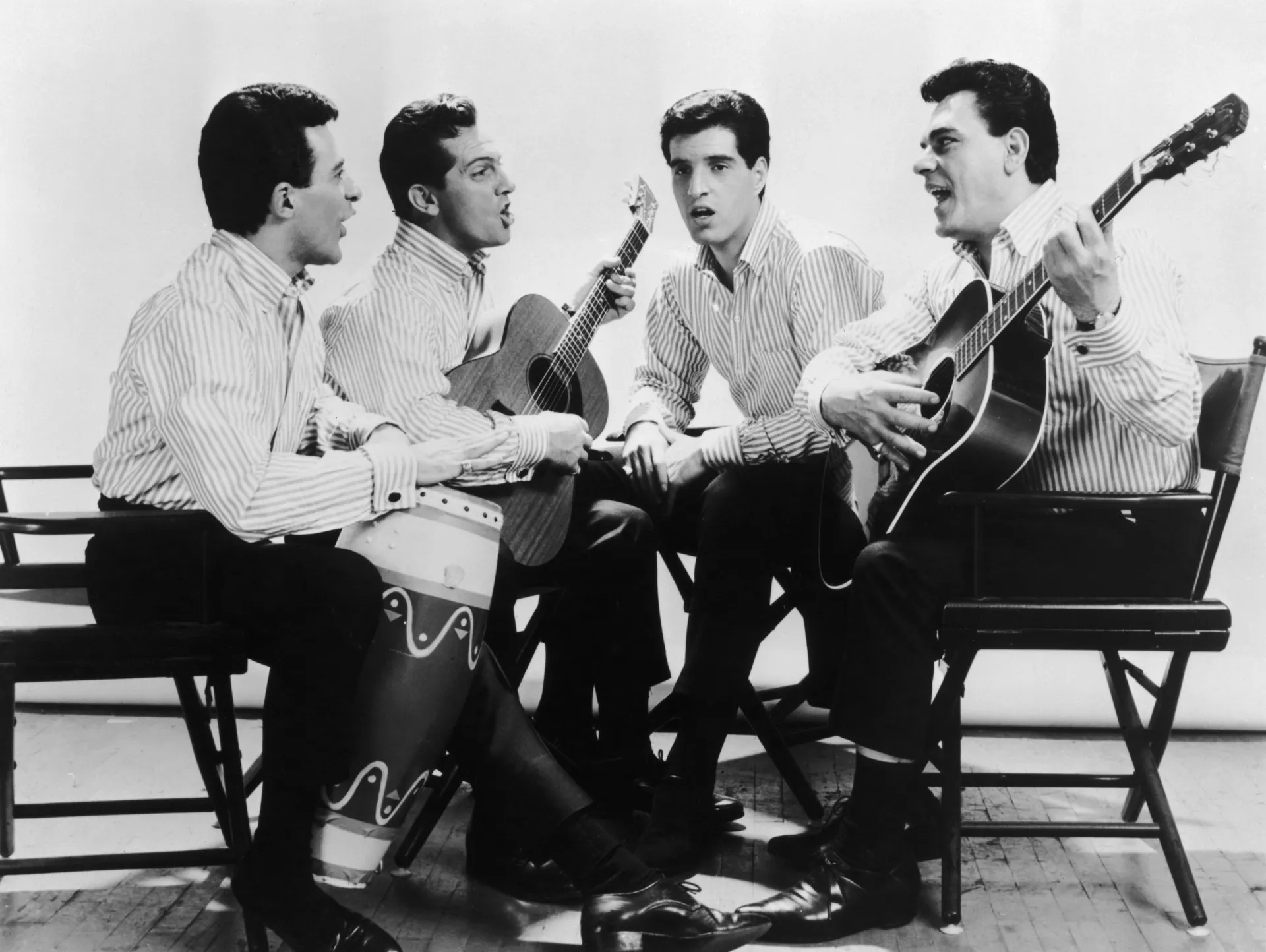 Frankie Valli e o grupo The Four Seasons em uma foto clássica em preto e branco.