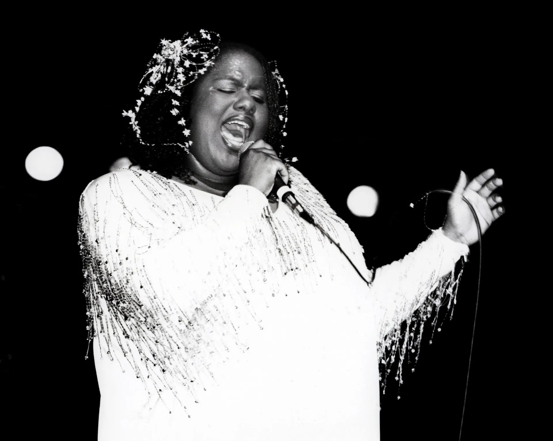 Jennifer Holliday cantando com uma paixão avassaladora em uma performance teatral.