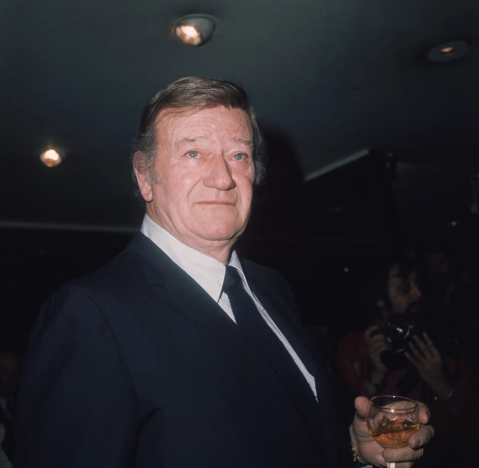 O ator John Wayne com seu chapéu de cowboy, um ícone dos filmes de faroeste.