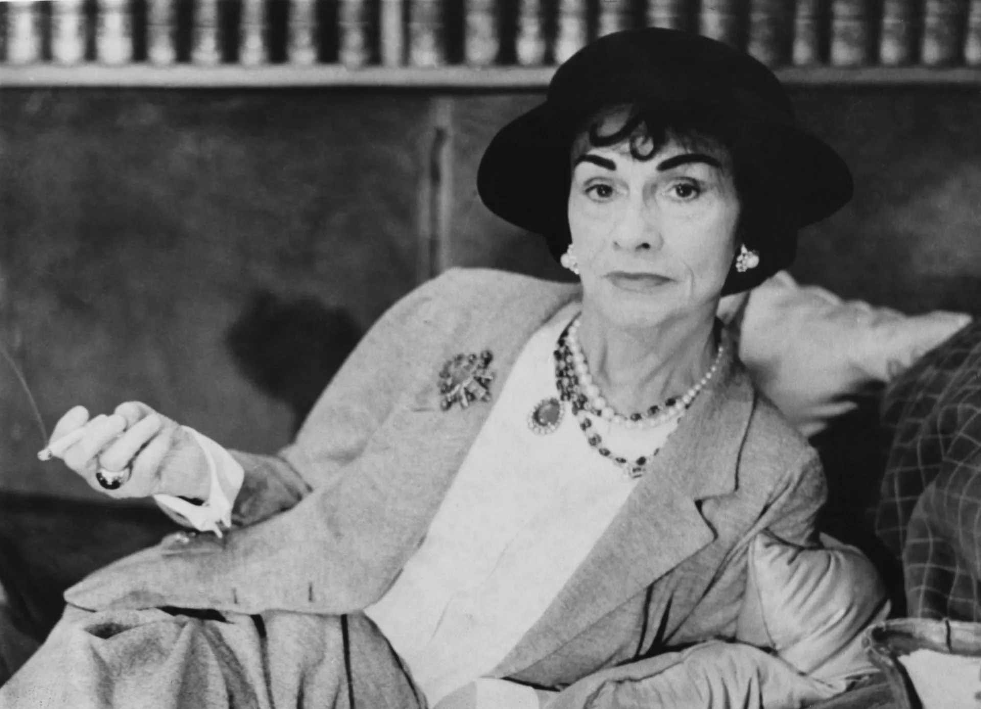 Coco Chanel, a icônica estilista francesa, em uma foto clássica em preto e branco.