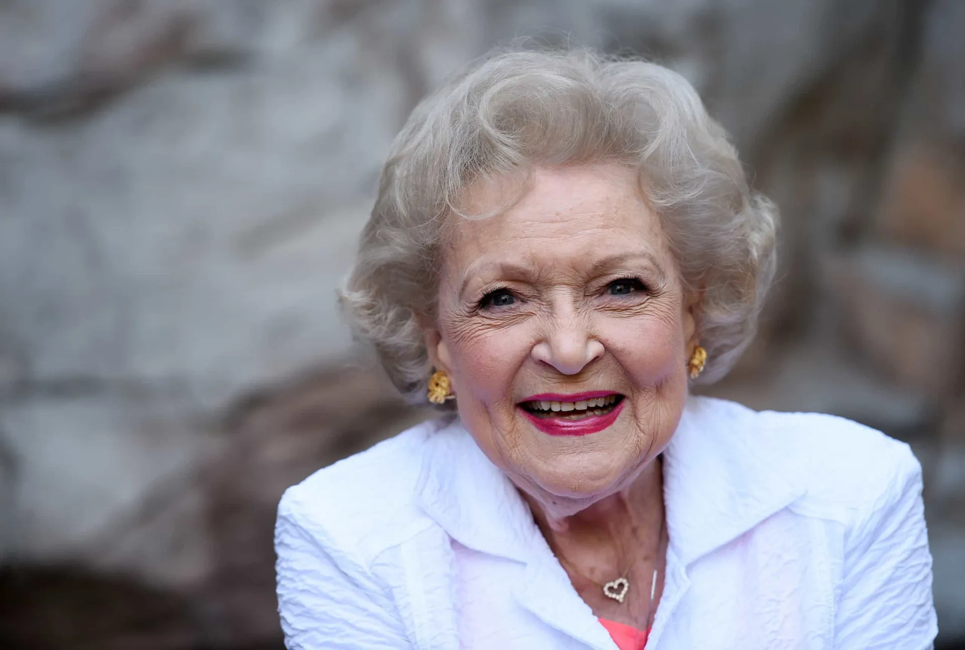 A atriz Betty White sorrindo, uma imagem que captura sua personalidade calorosa e divertida.