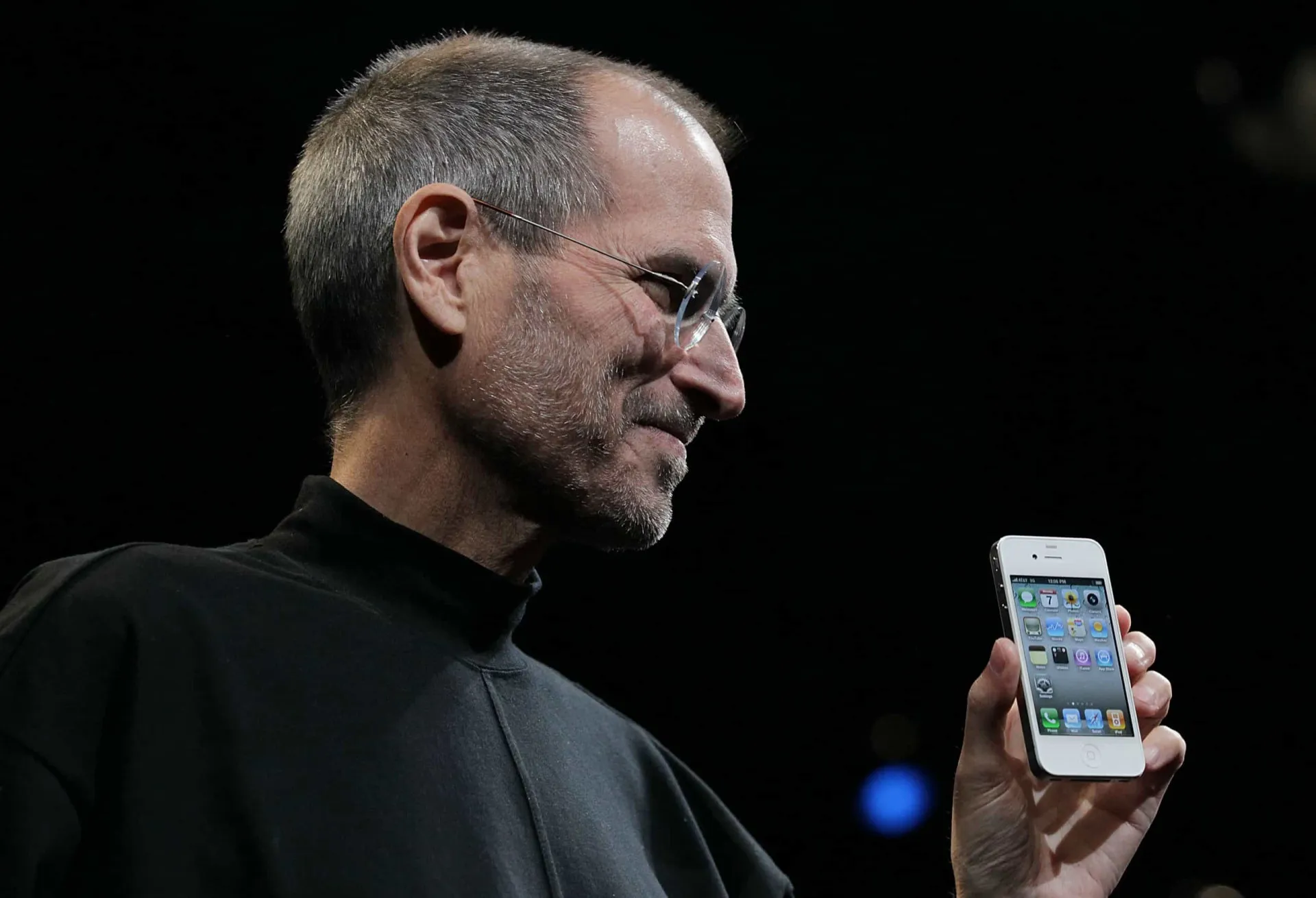 Steve Jobs, co-fundador da Apple, com seu icônico suéter preto de gola alta e óculos redondos.