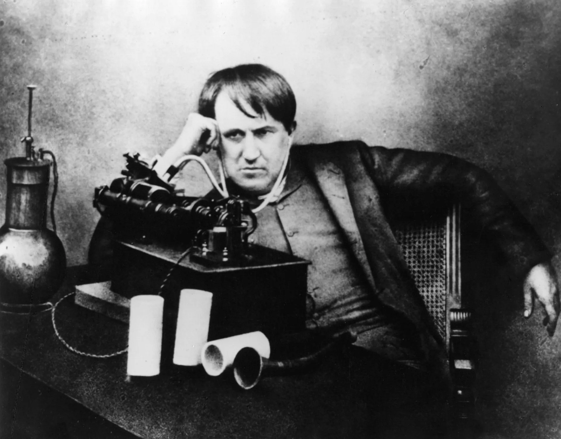 O inventor Thomas Edison em seu laboratório, cercado por equipamentos e criações.