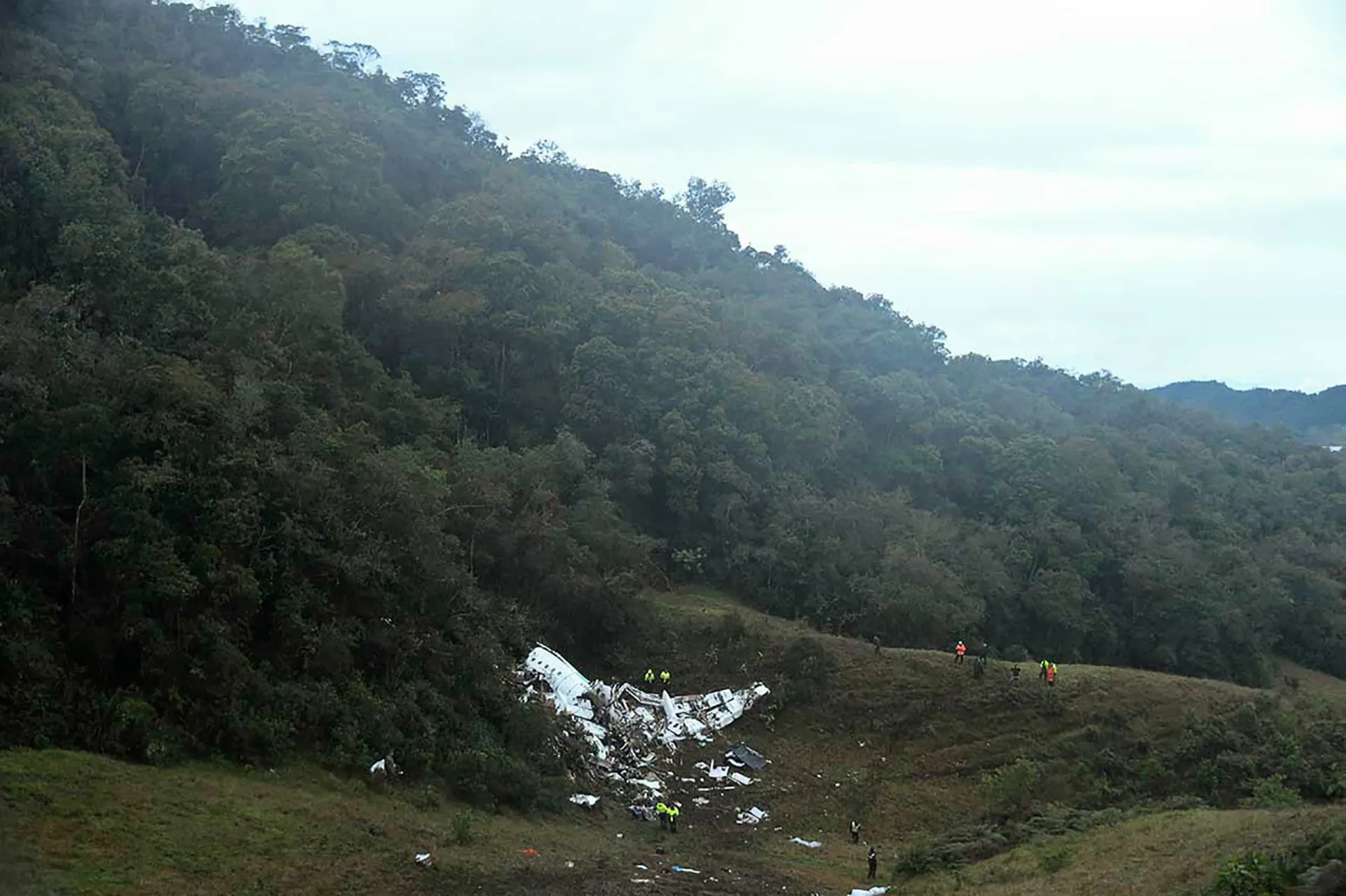 Destroços do avião da LaMia espalhados em uma encosta de montanha na Colômbia.