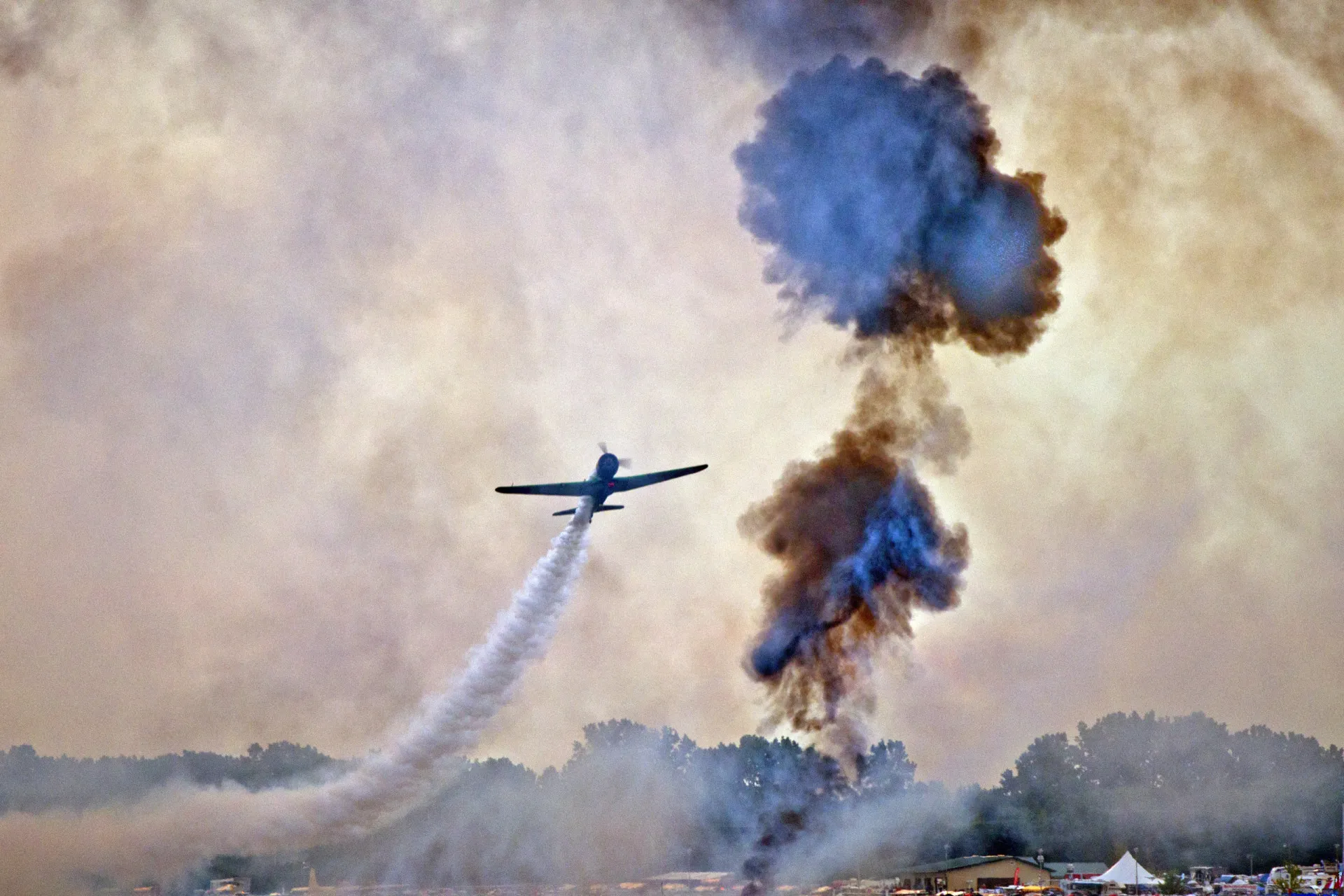 Um avião de treinamento militar vintage T-6 Texan voando baixo sobre a água.