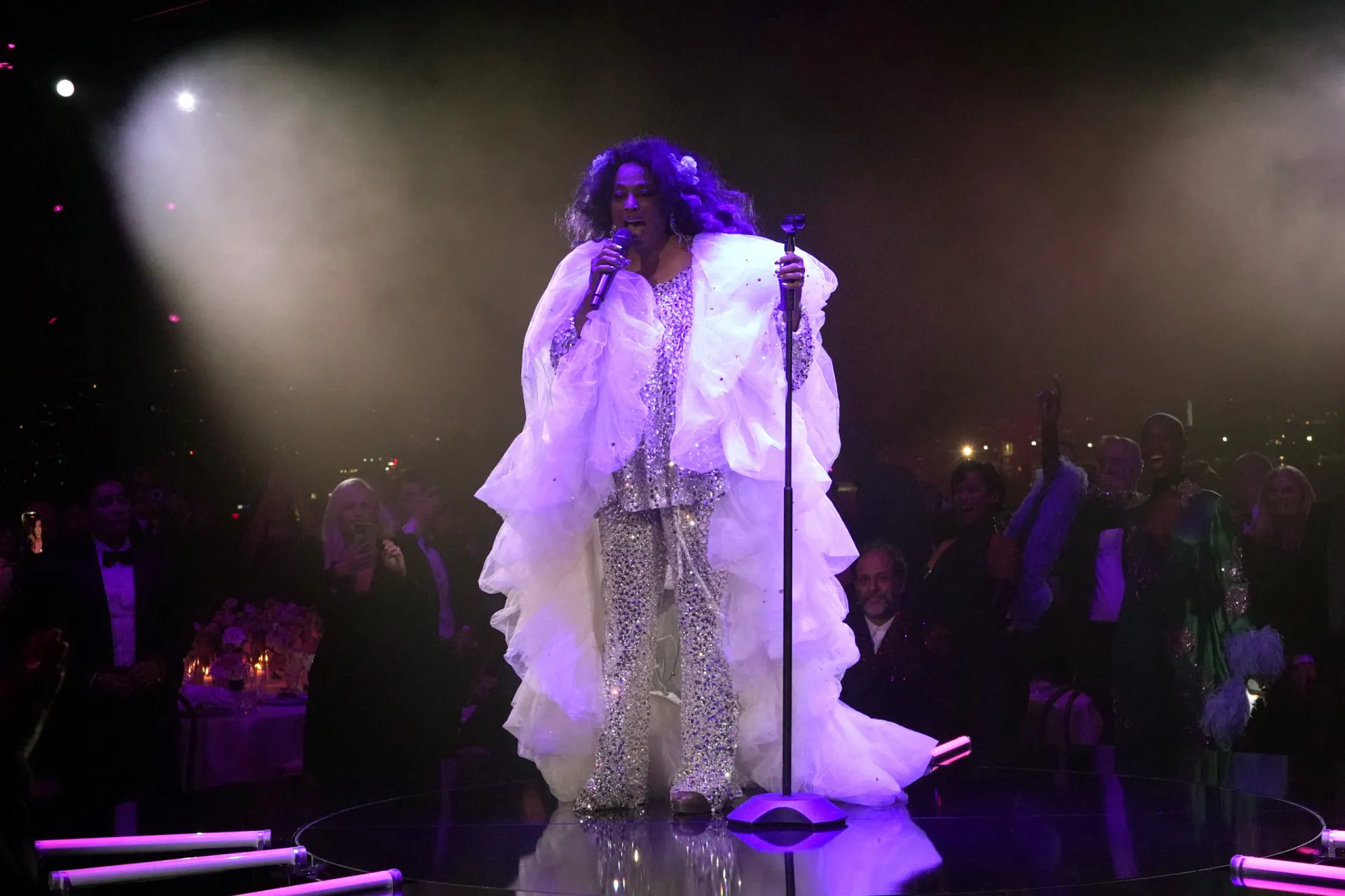 Diana Ross com um visual glamoroso, cheio de brilho e cabelos volumosos.
