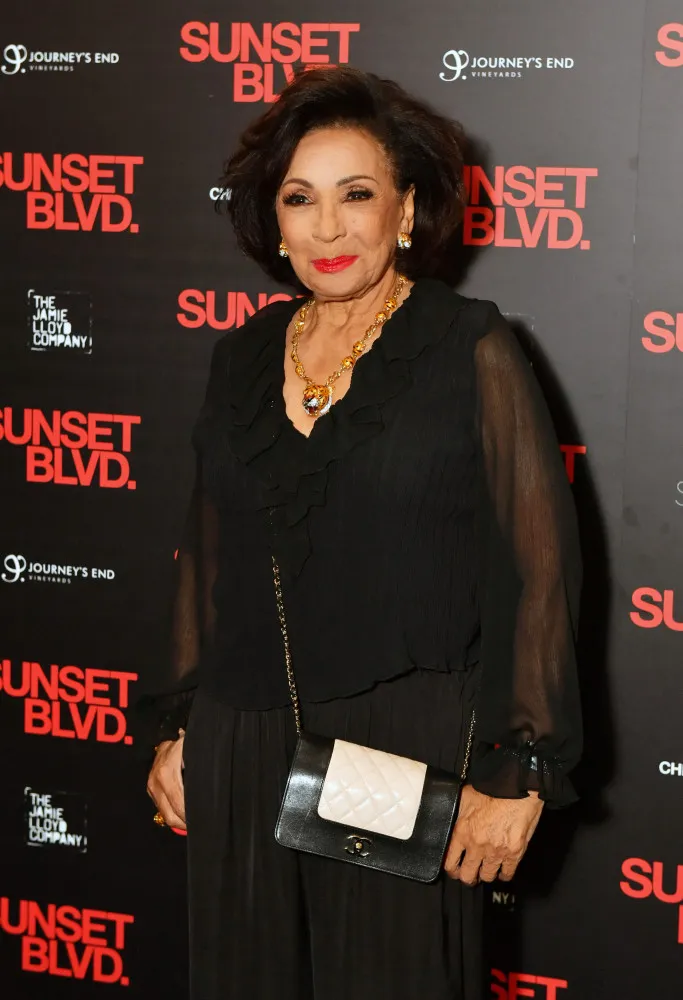 Dame Shirley Bassey cantando com paixão, uma imagem que captura seu poder vocal.