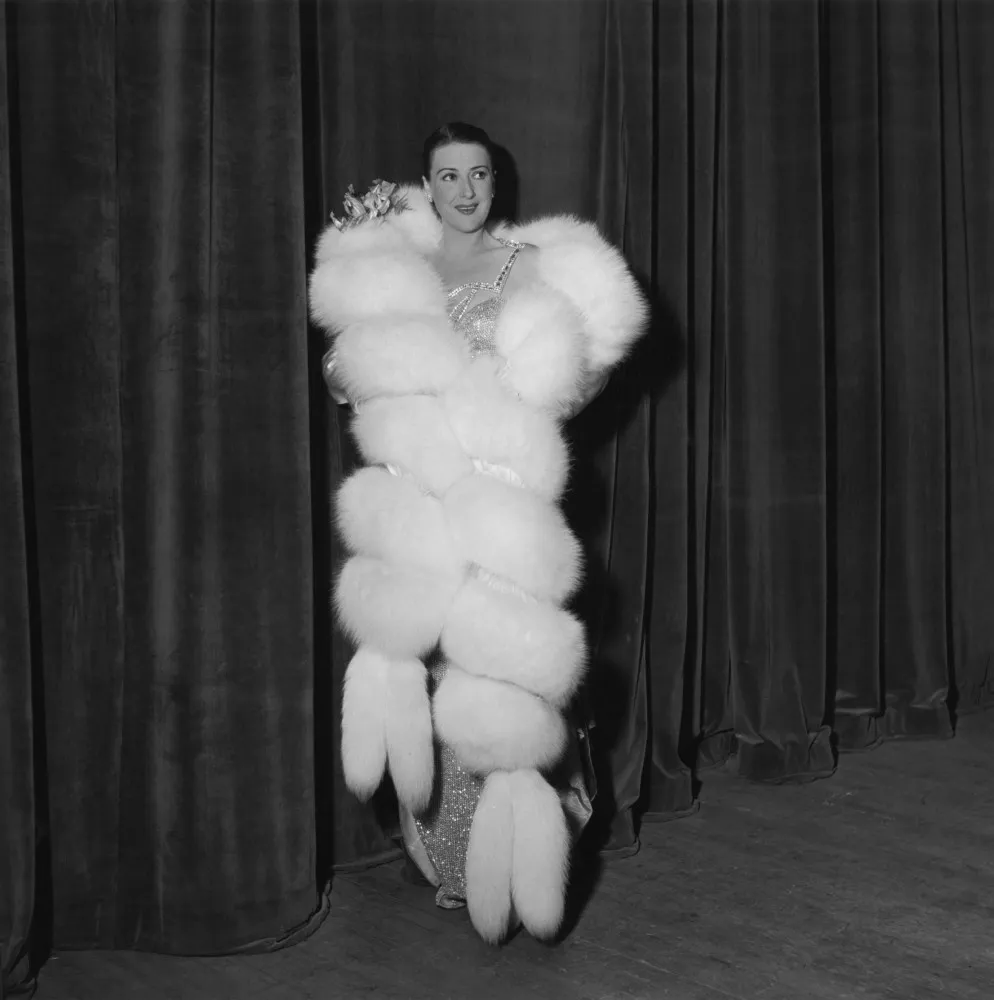 Gypsy Rose Lee com um visual glamouroso, típico da era de ouro de Hollywood.