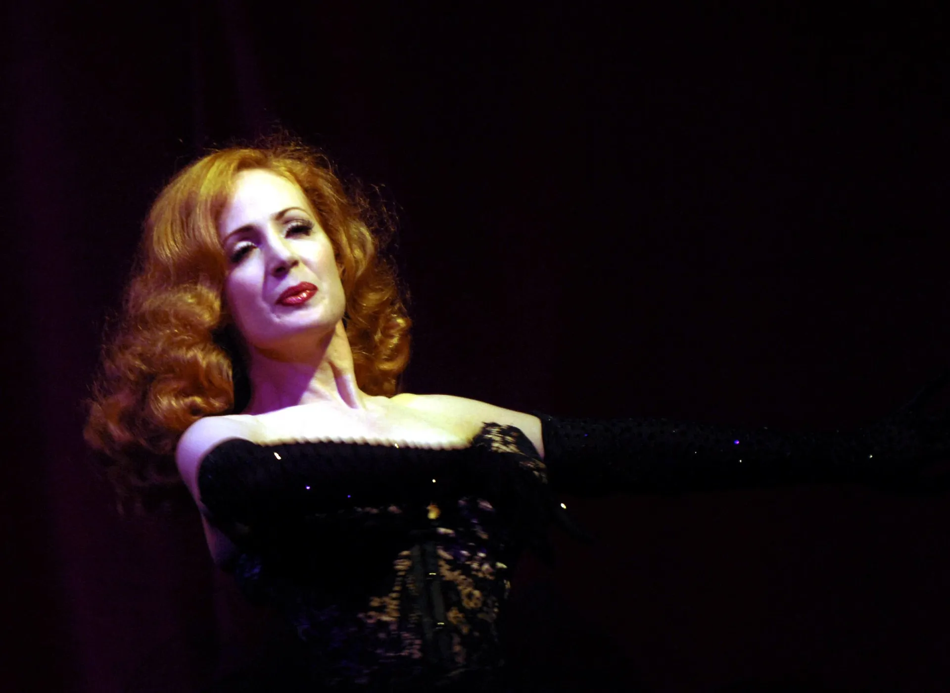 Catherine D'lish em uma pose artística, destacando seu figurino detalhado.