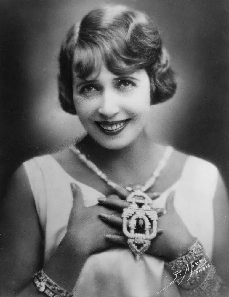 Mistinguett em um close-up, destacando sua beleza e o estilo da época.