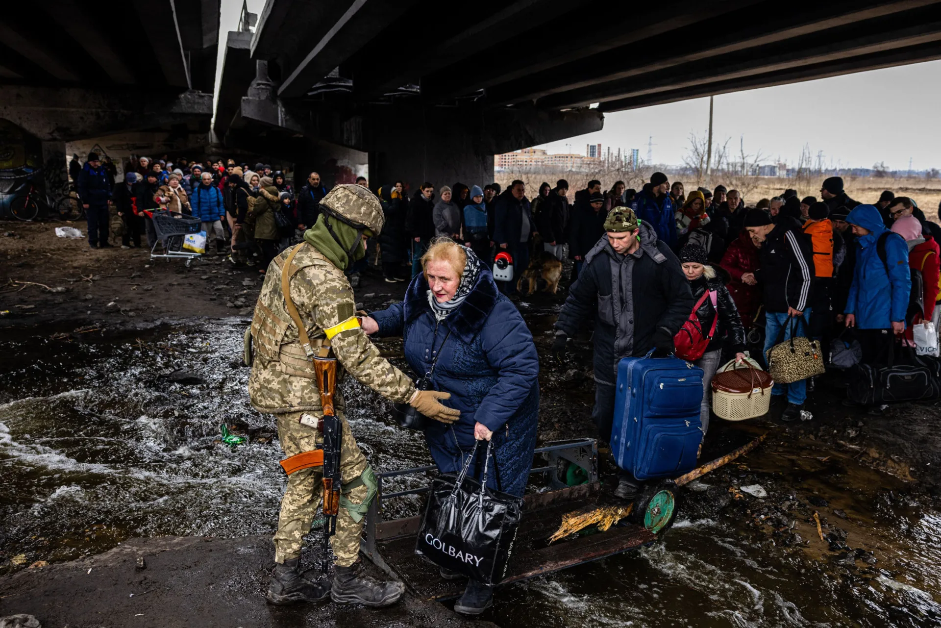 Família de refugiados caminhando por uma estrada, carregando seus pertences.