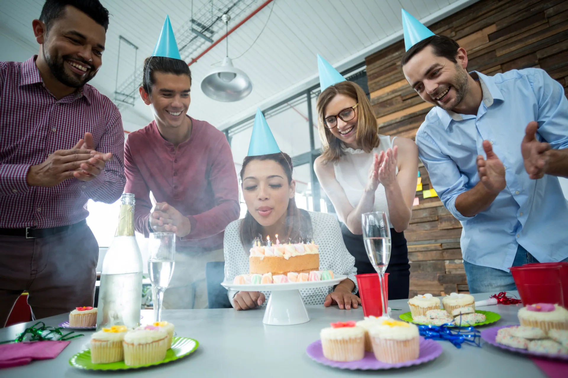 Um bolo de aniversário com velas acesas, pronto para a canção de parabéns.