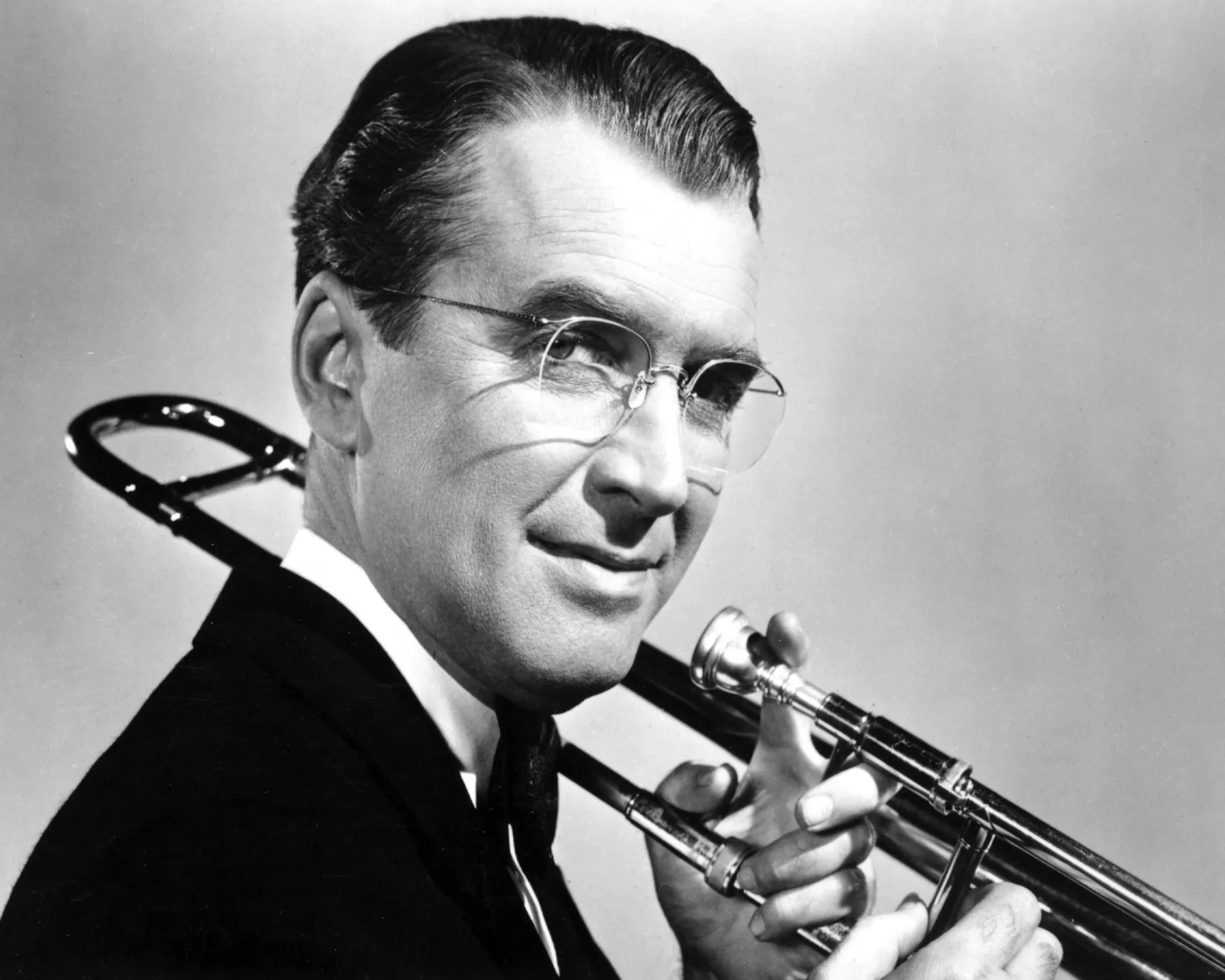 Retrato do famoso maestro Glenn Miller, sorrindo em seu uniforme militar.
