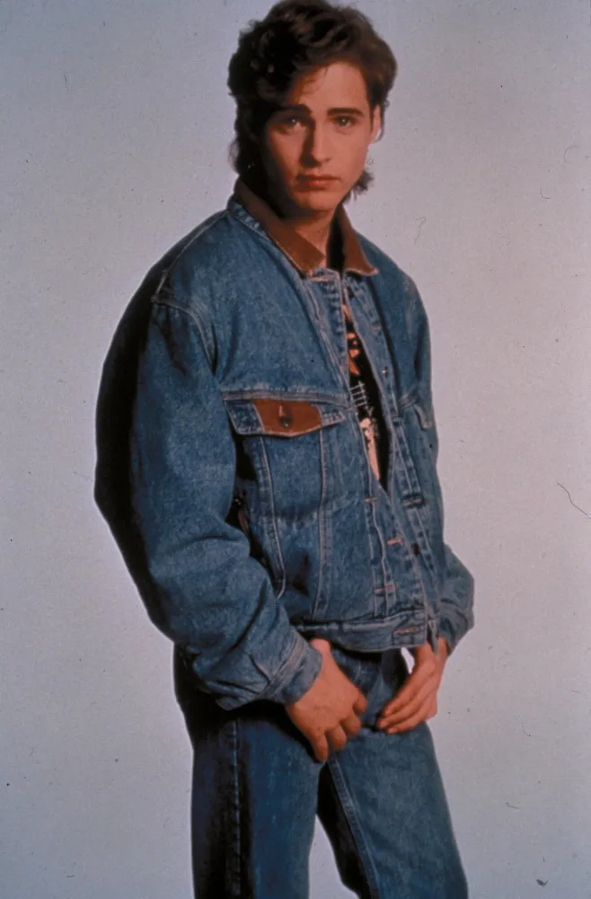 Jason Priestley em uma foto mais recente, com um sorriso charmoso e aparência madura.