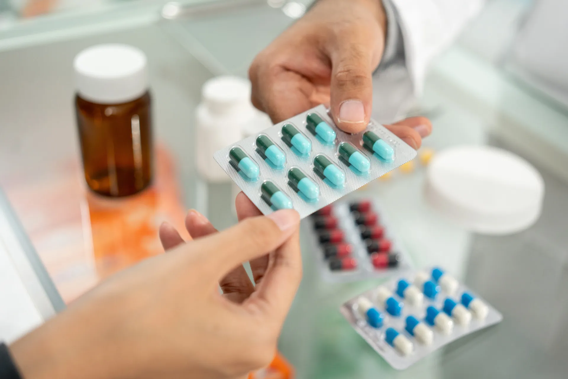 Vários tipos de pílulas e medicamentos espalhados sobre uma superfície.